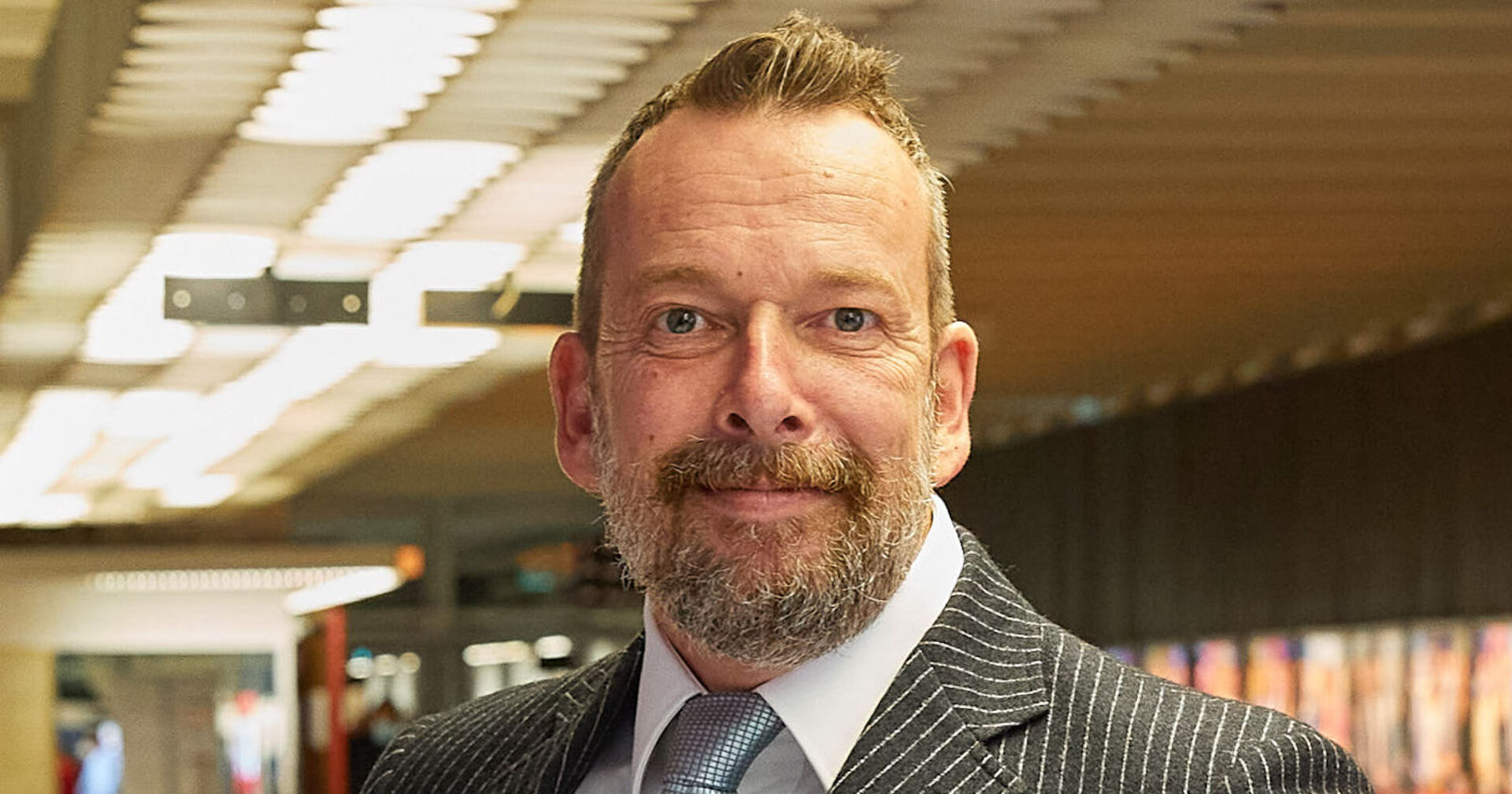 Robert Kratky steht im ORF Zentrum. Er trägt einen gestreiften Anzug.