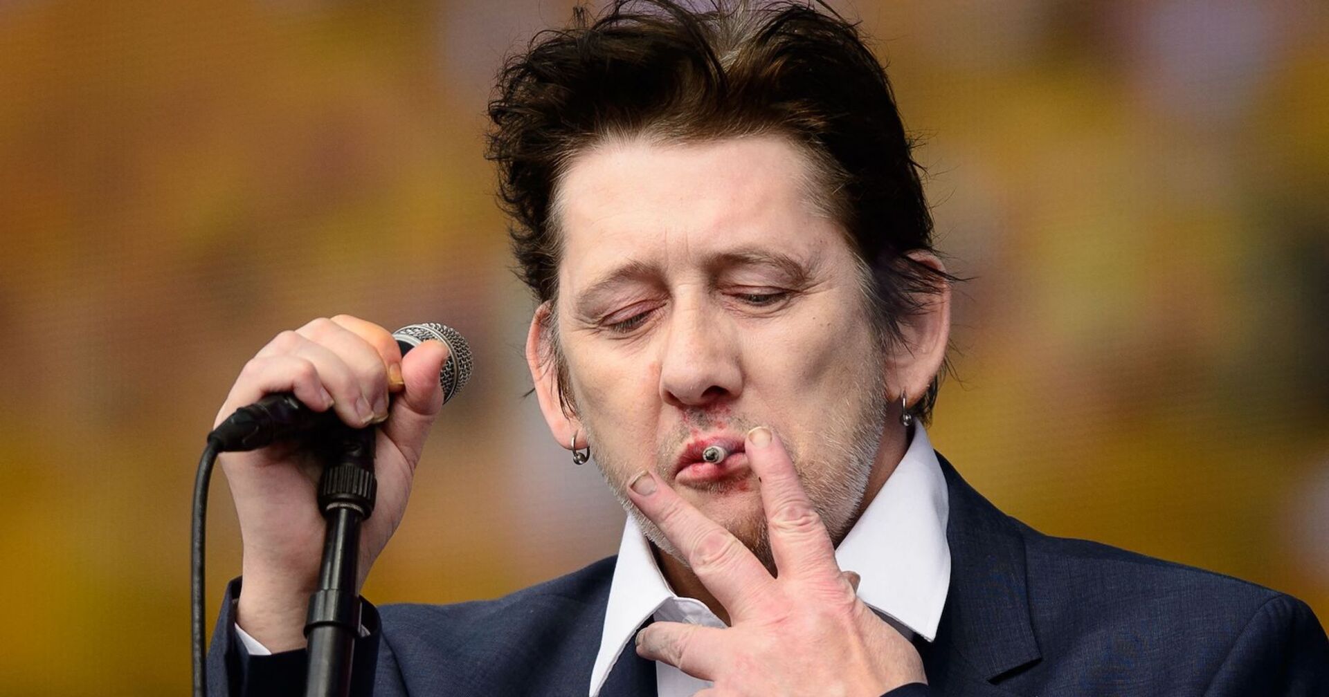 Shane MacGowan 2014 rauchend auf der Bühne.