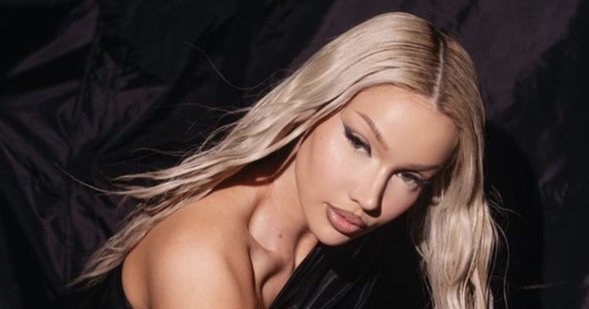 Shirin David trägt offene, platinblonde, lange Haare und ein starkes Augen Make-Up.