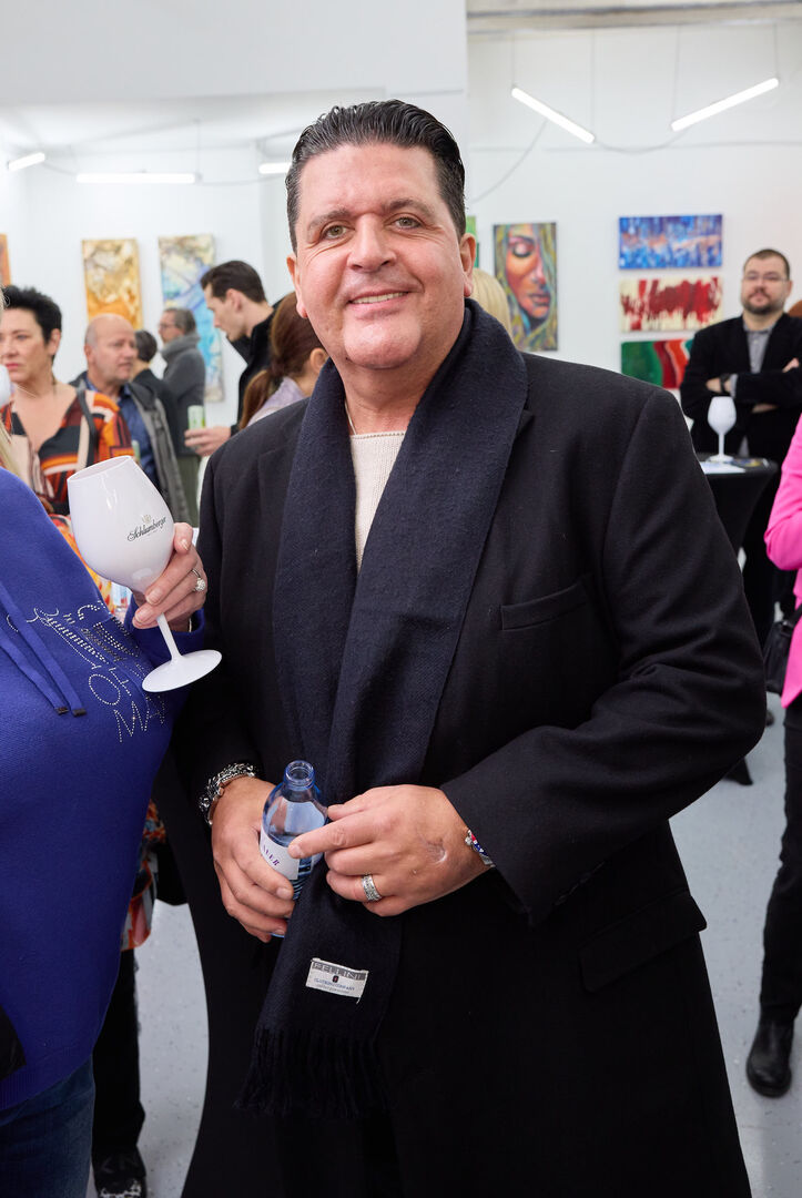 Tony Wegas mit einem schwarzen Langen Mantel und einem schwarzen Schal.