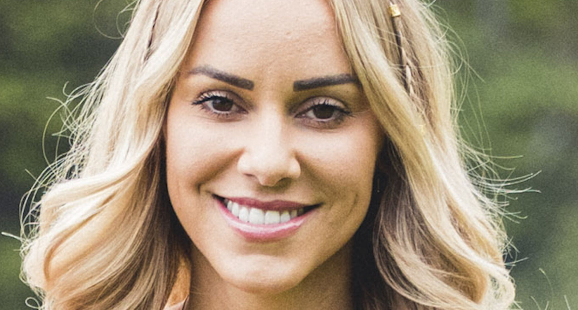 Vanessa Mariposa lächelt mit offenen blonden Haaren in die Kamera.