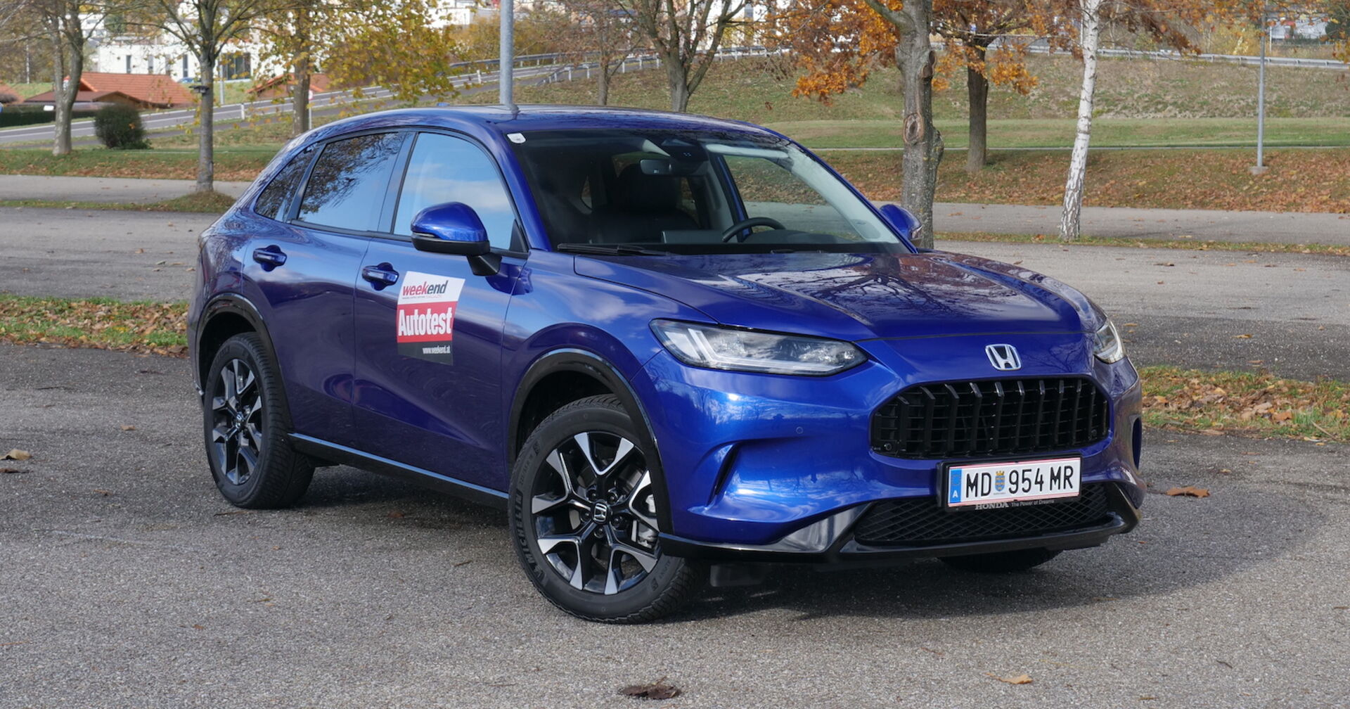 Ein dunkelblauer Honda Z-RV auf einem Parkplatz in herbstlicher Umgebung