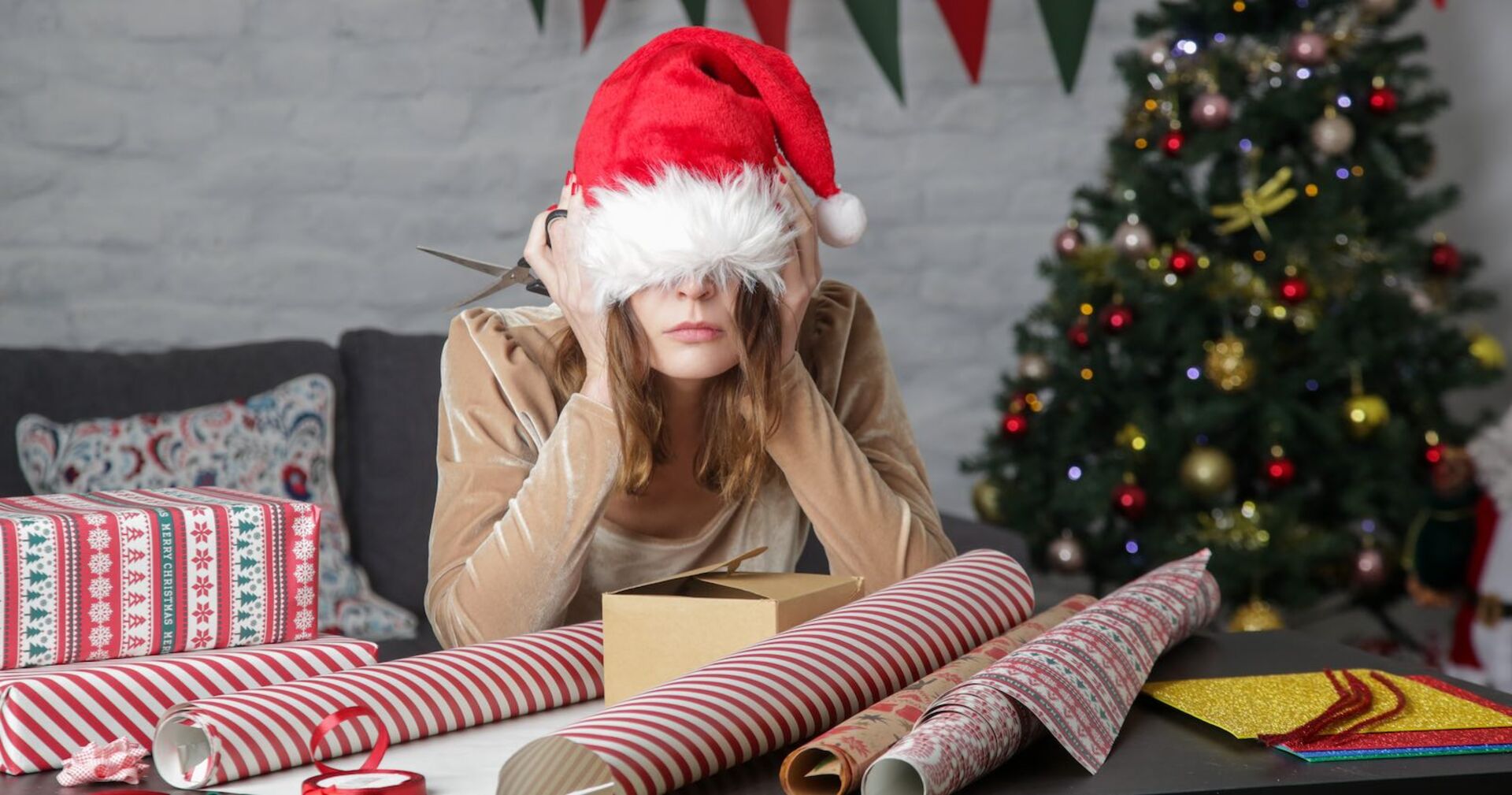 Eine genervte Frau zieht sich die rote Zipfelmütze über das Gesicht.