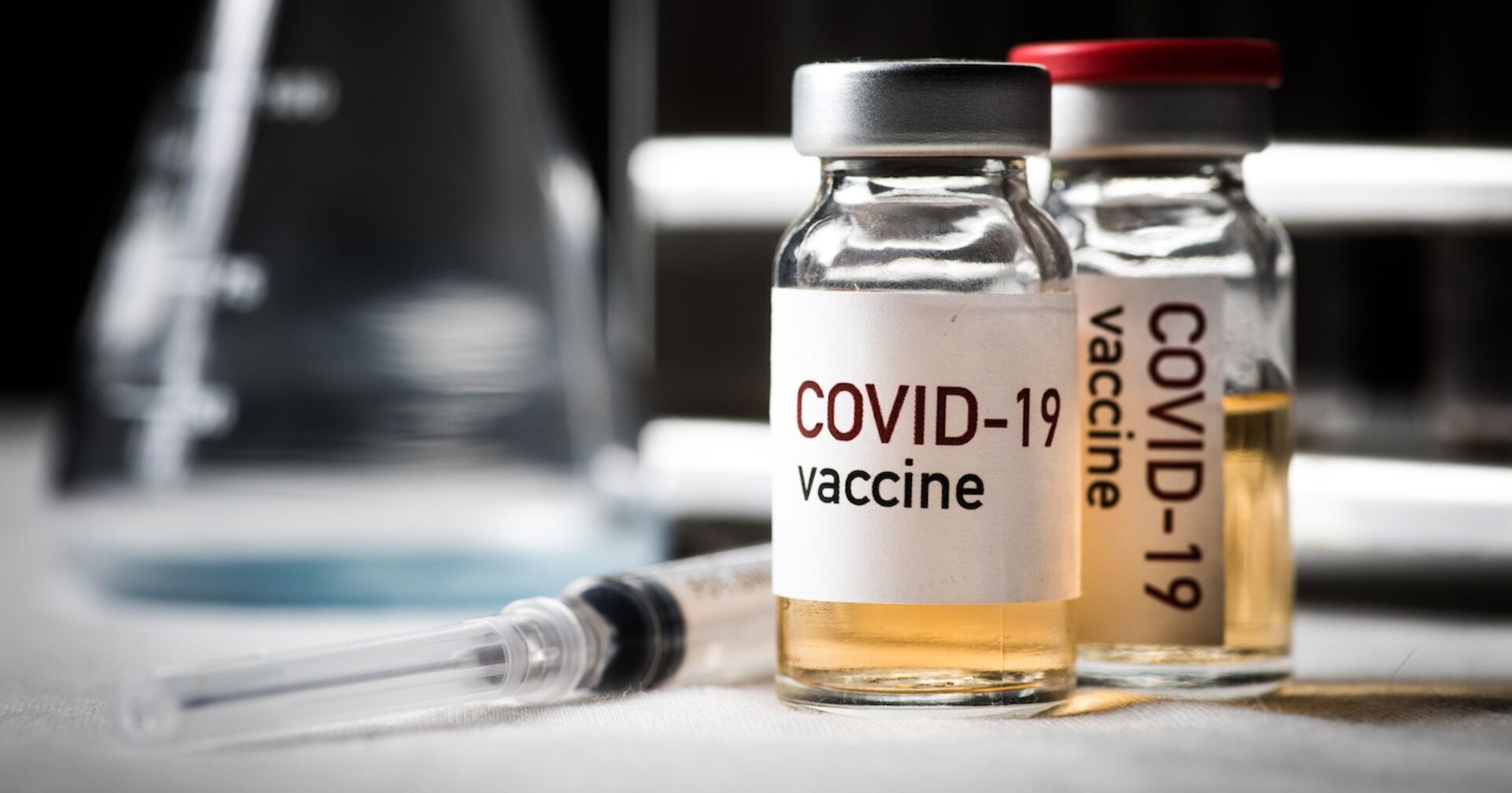 Spritze und Impfstoff gegen Corona in Fläschchen.