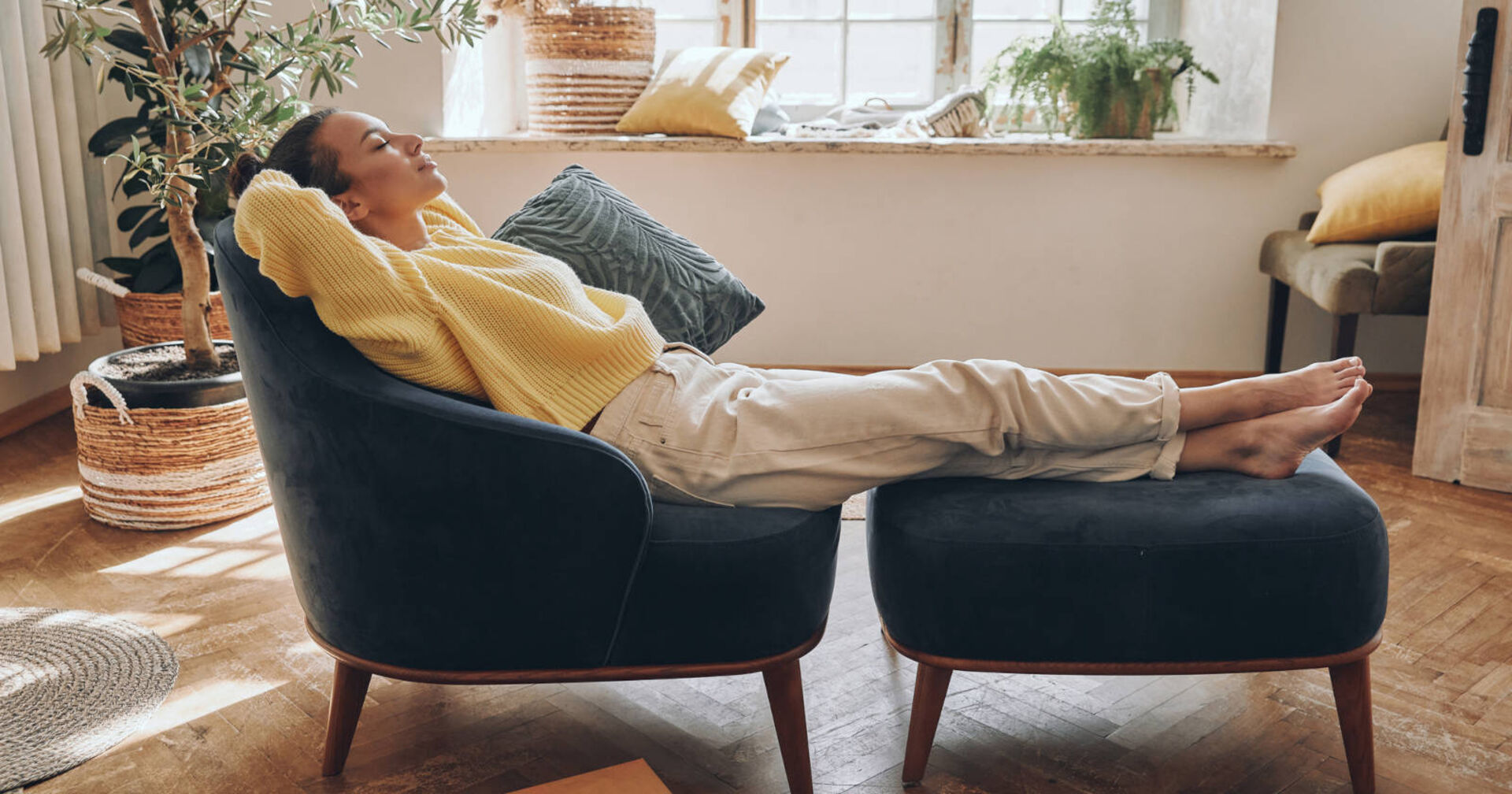 Frau entspannt sich im Wohnzimmer.