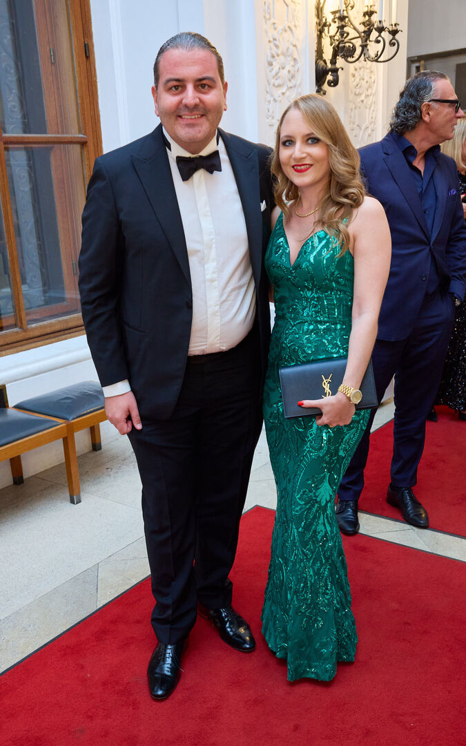 Leopold Kohlbauer trägt einen schwarzen Smoking und Jacky Lugner ein grünes Glitzerkleid.