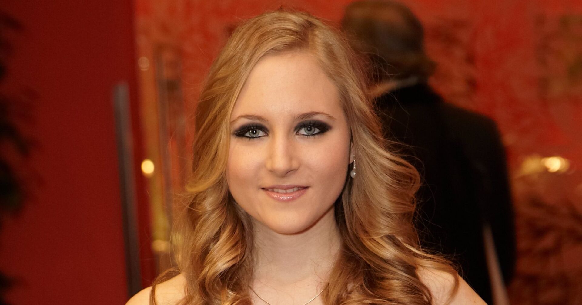 Jaqueline Lugner mit gewellten blonden Haare und starken Augen Make Up.