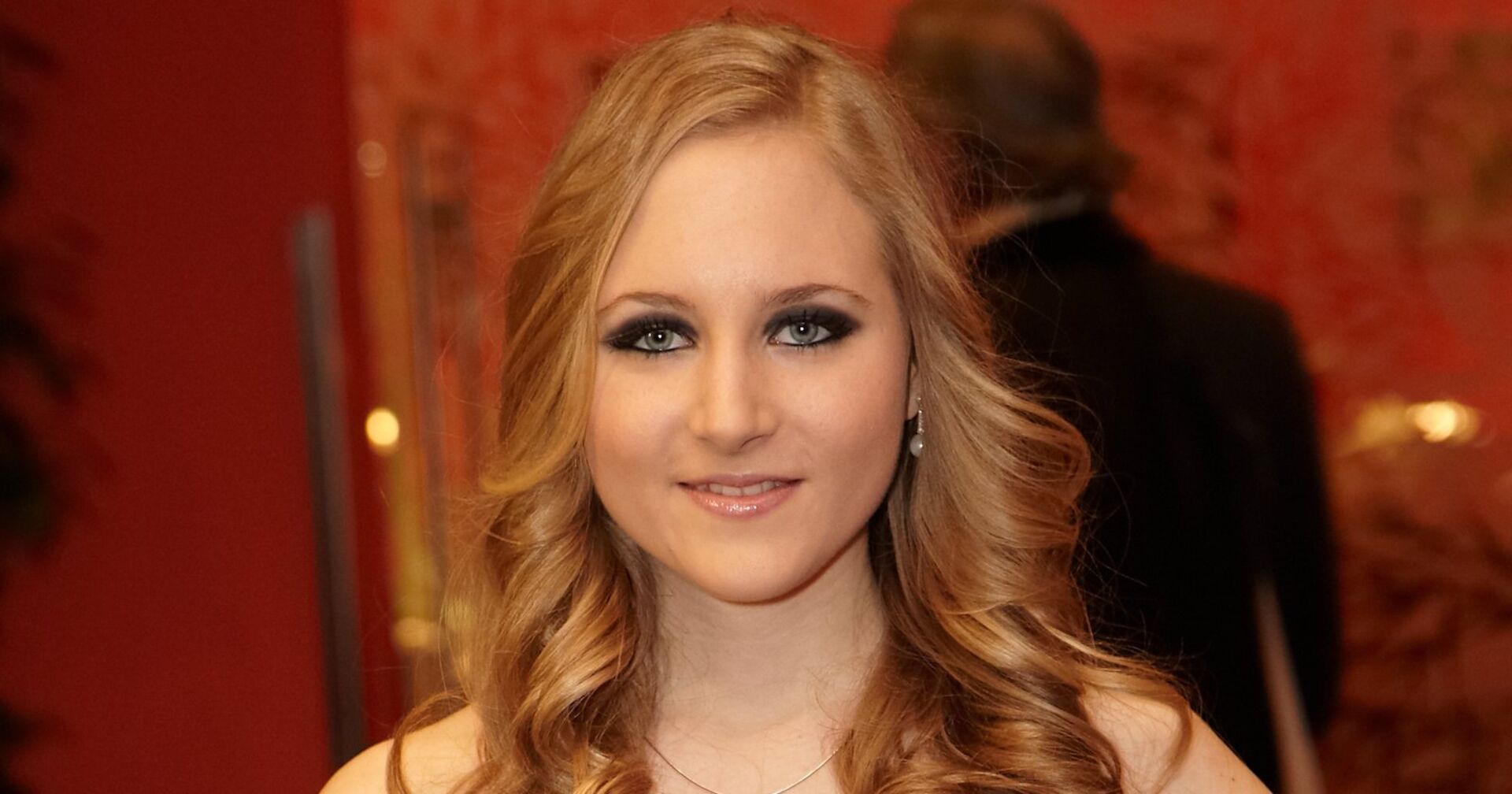 Jaqueline Lugner mit blonden, gewellten Haaren und schwarz geschminkten Augen.