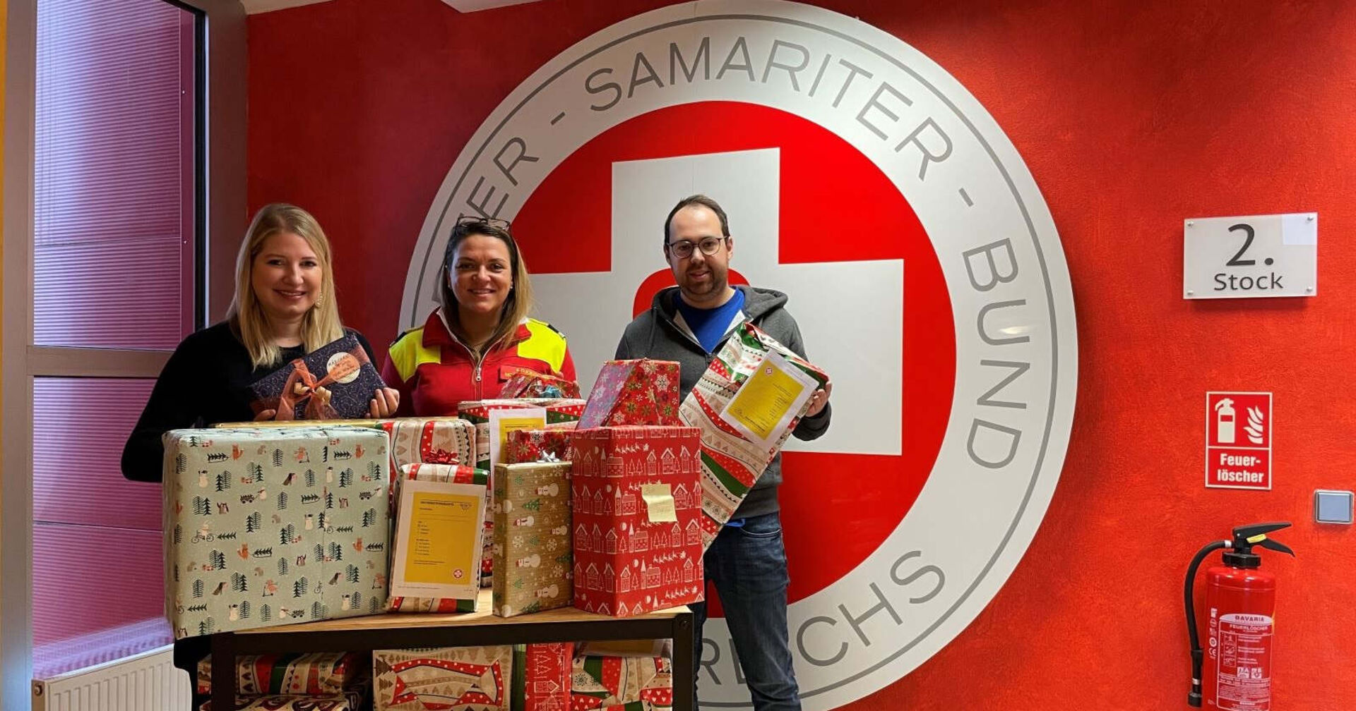 Drei Personen im Bild bei der feierlichen Scheckübergabe an den Samariterbund Salzburg