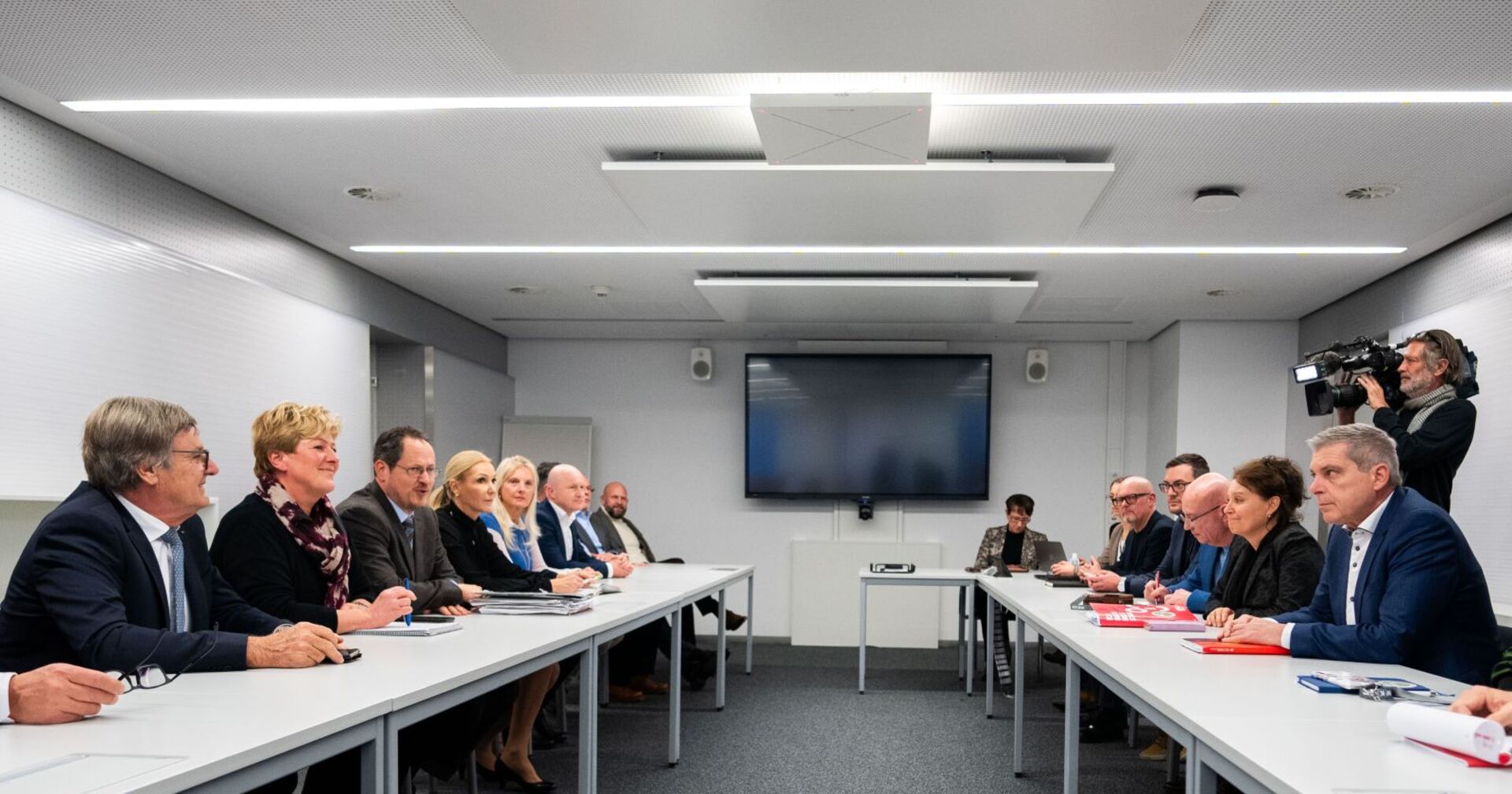 Die Verhandler sitzen an den Tischen.