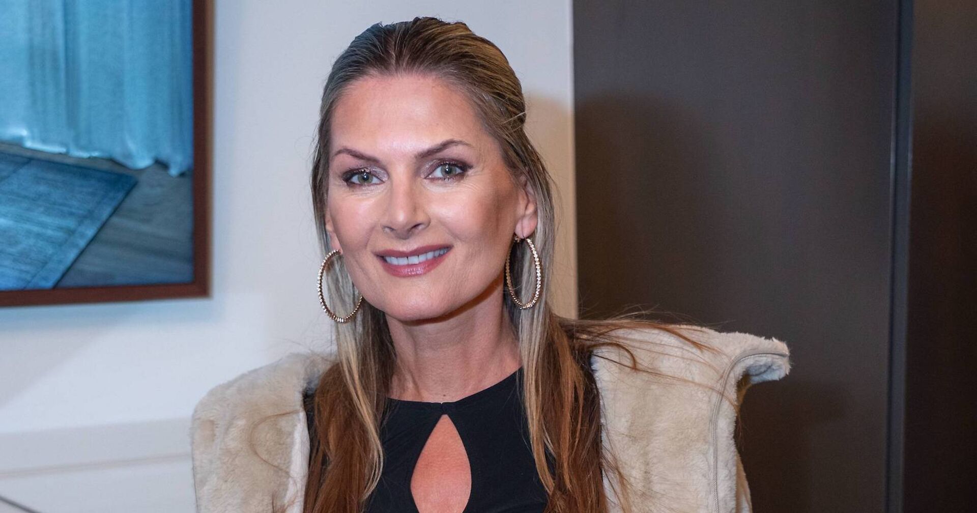 Martina Kaiser mit einem schwarzen Kleid und beigem Mantel.