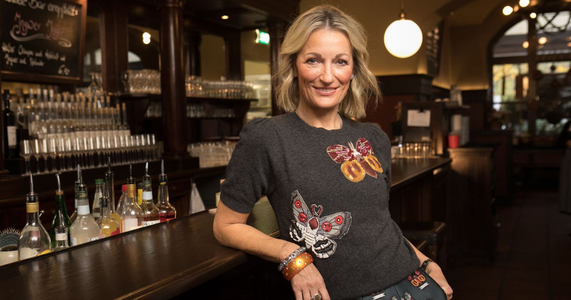 Monika Gruber lehnt an einer Bar.