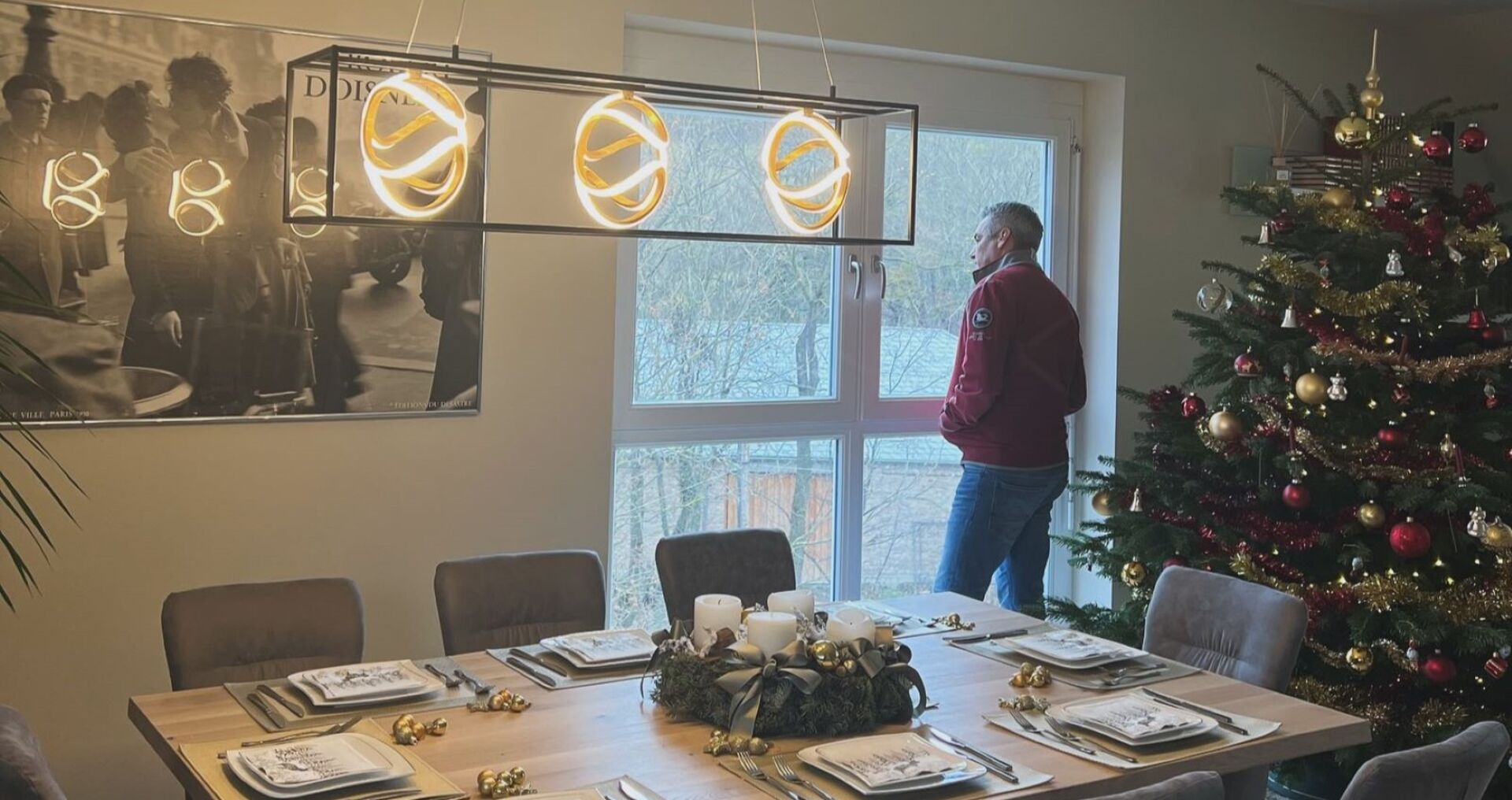 Karl Nehammer vor einem festlich gedeckte Tisch und dem Weihnachtsbaum. Er schaut aus dem Fenster.