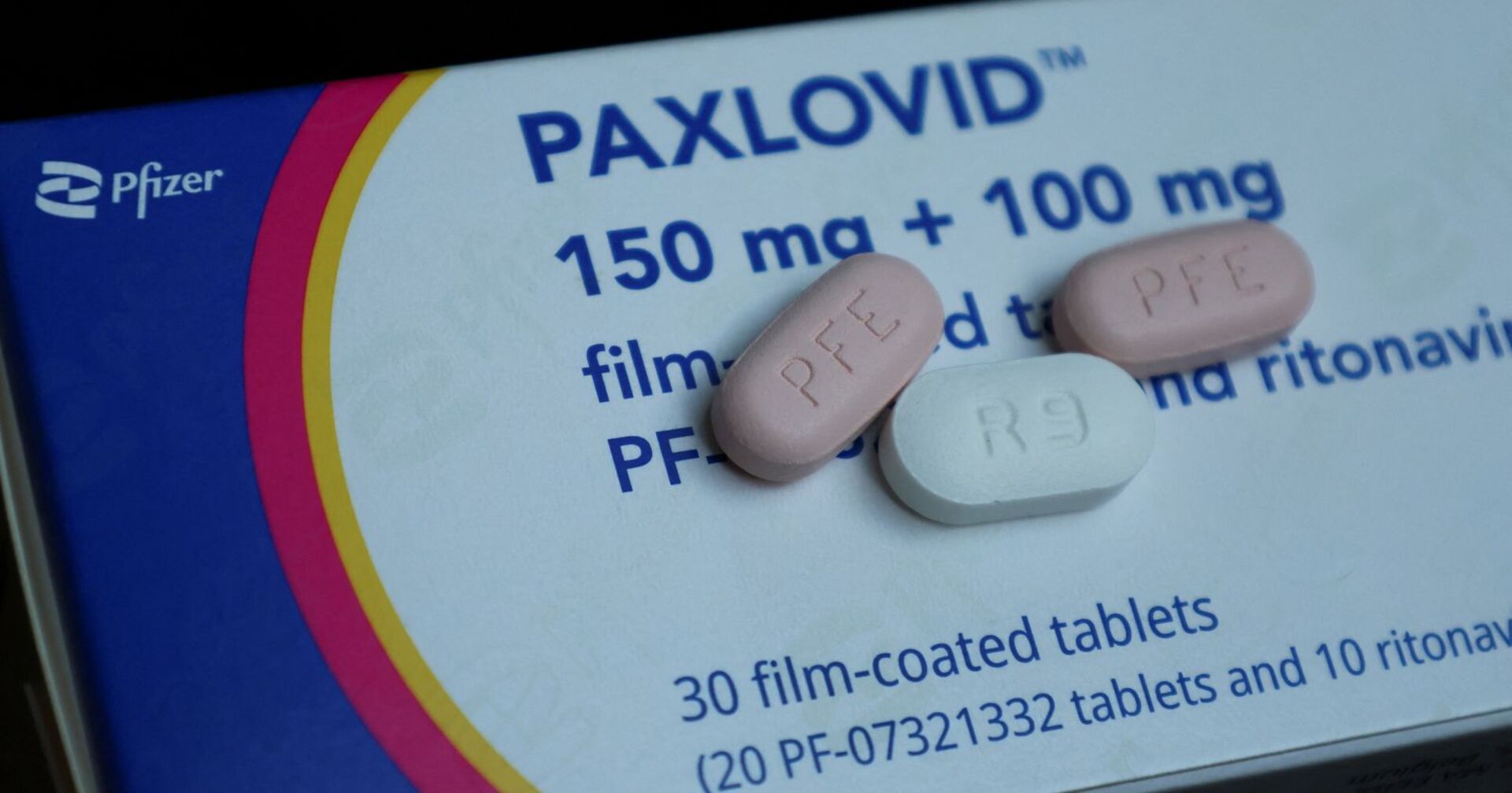 Eine Packung Paxlovid und drei einzelne Tabletten.