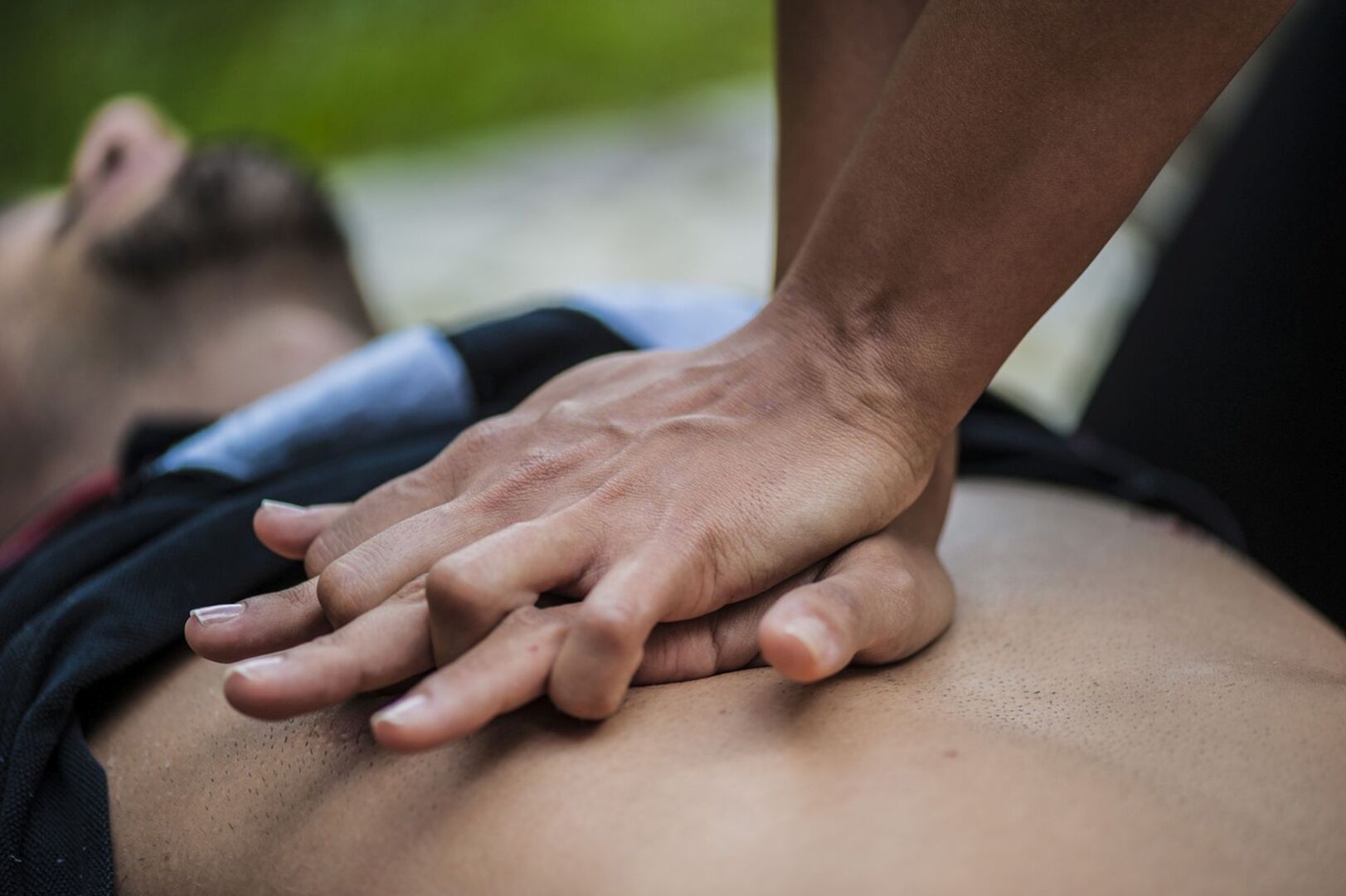Ein Mann versucht einen anderen Mann mit Herzdruckmassage wiederzubelben.