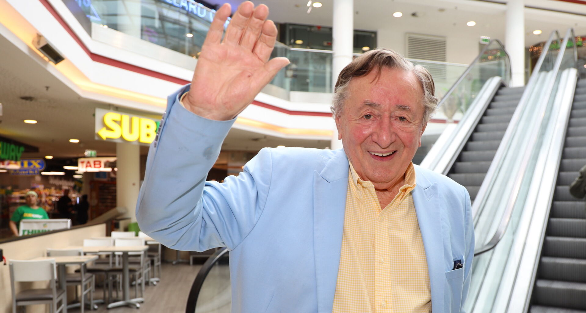 Richard Lugner in einem hellblauen Sakko und einem gelben Hemd.