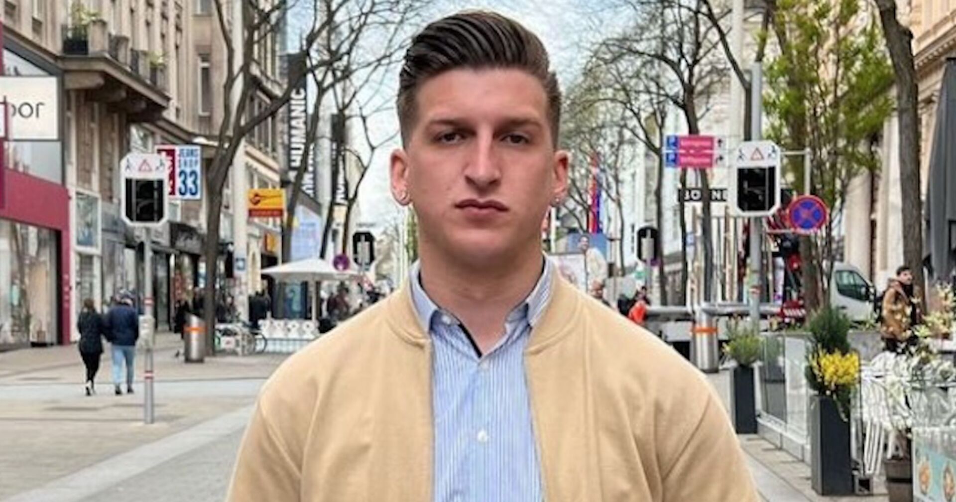 Satans Bratan auf der Wiener Mariahilferstraße mit einem Hemd und einer beigen Weste.