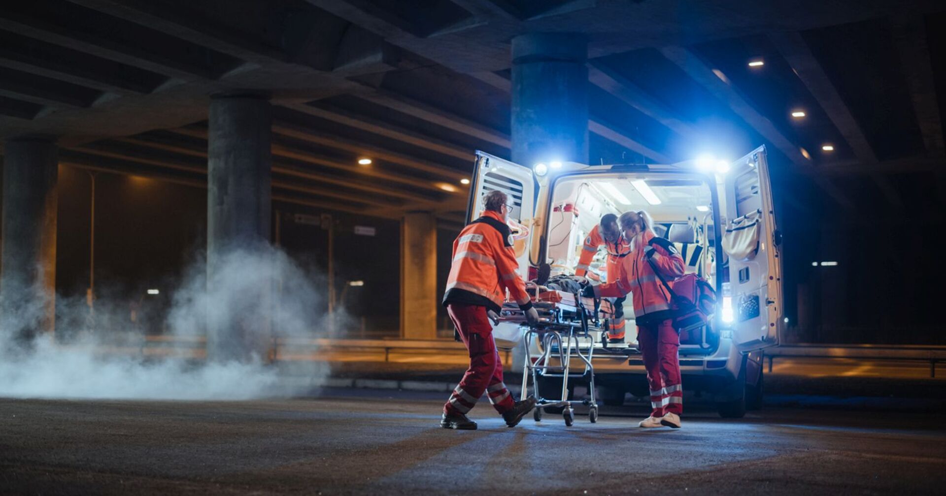 Einsatzkräfte bringen Verletzten in einen Krankenwagen.