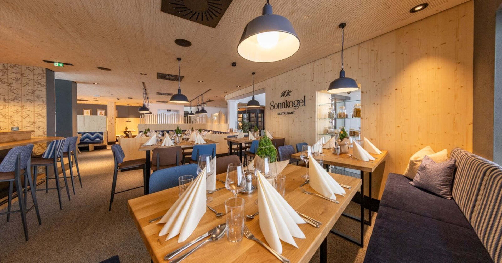 Das erneuerte Sonnkogel Restaurant von innen mit viel Holz und moderner Einrichtung.