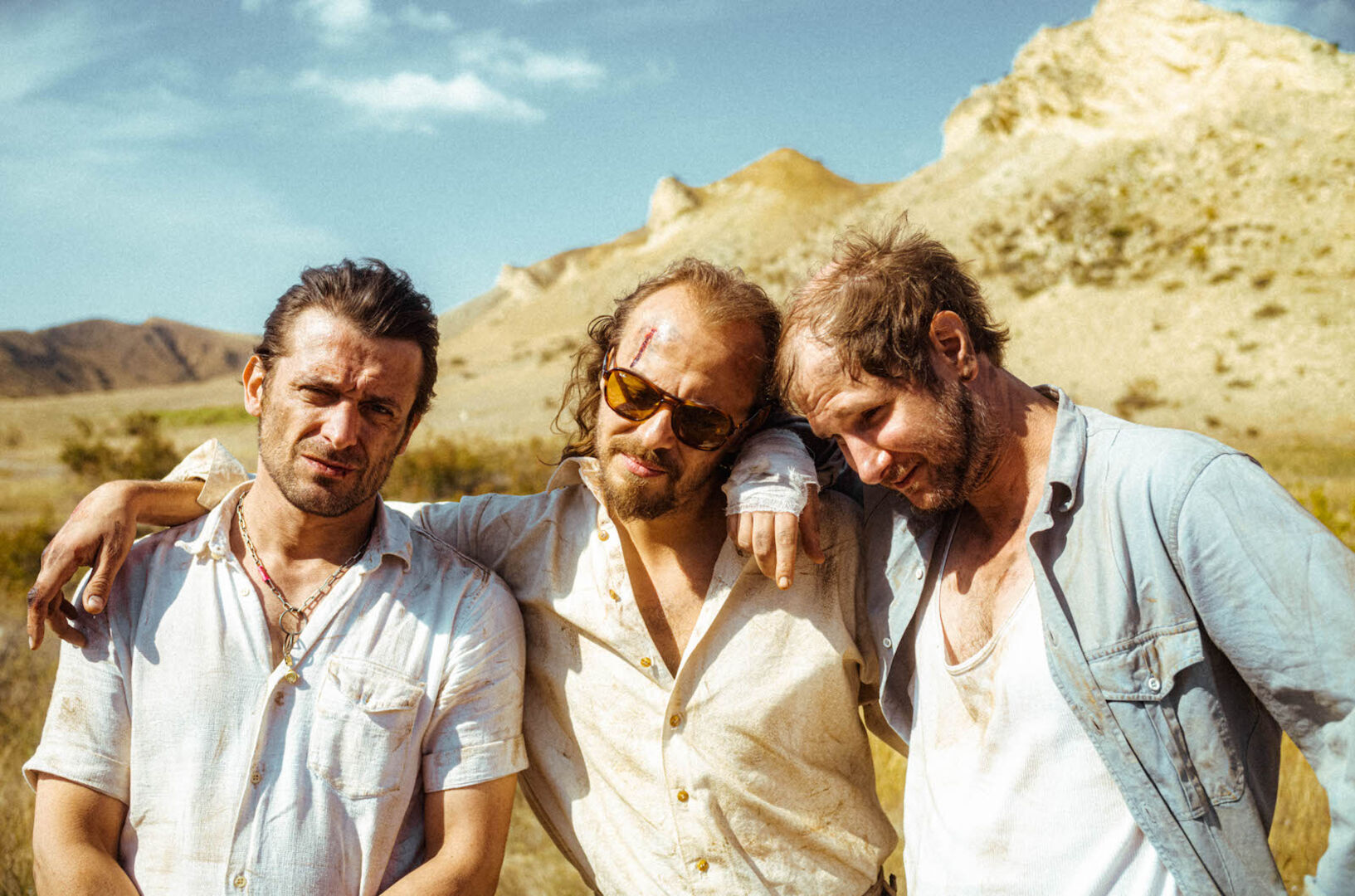 Manu, Ray und Marco von Wanda. Sie sind bei einem Fotoshooting und umarmen sich selbst.