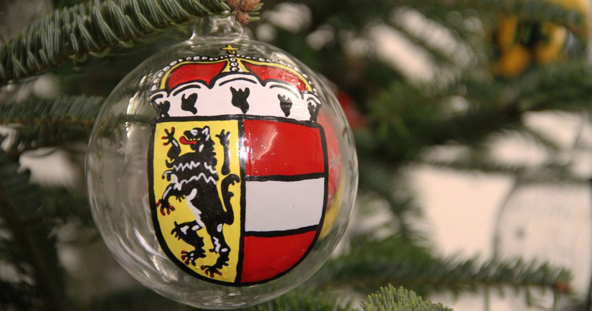 Weihnachtskugel mit dem Salzburg Wappen auf einem Christbaum.