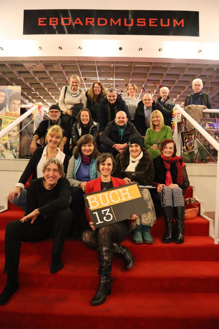 Buch13-Mitwirkende sitzen auf der Stiege im Eboardmuseum