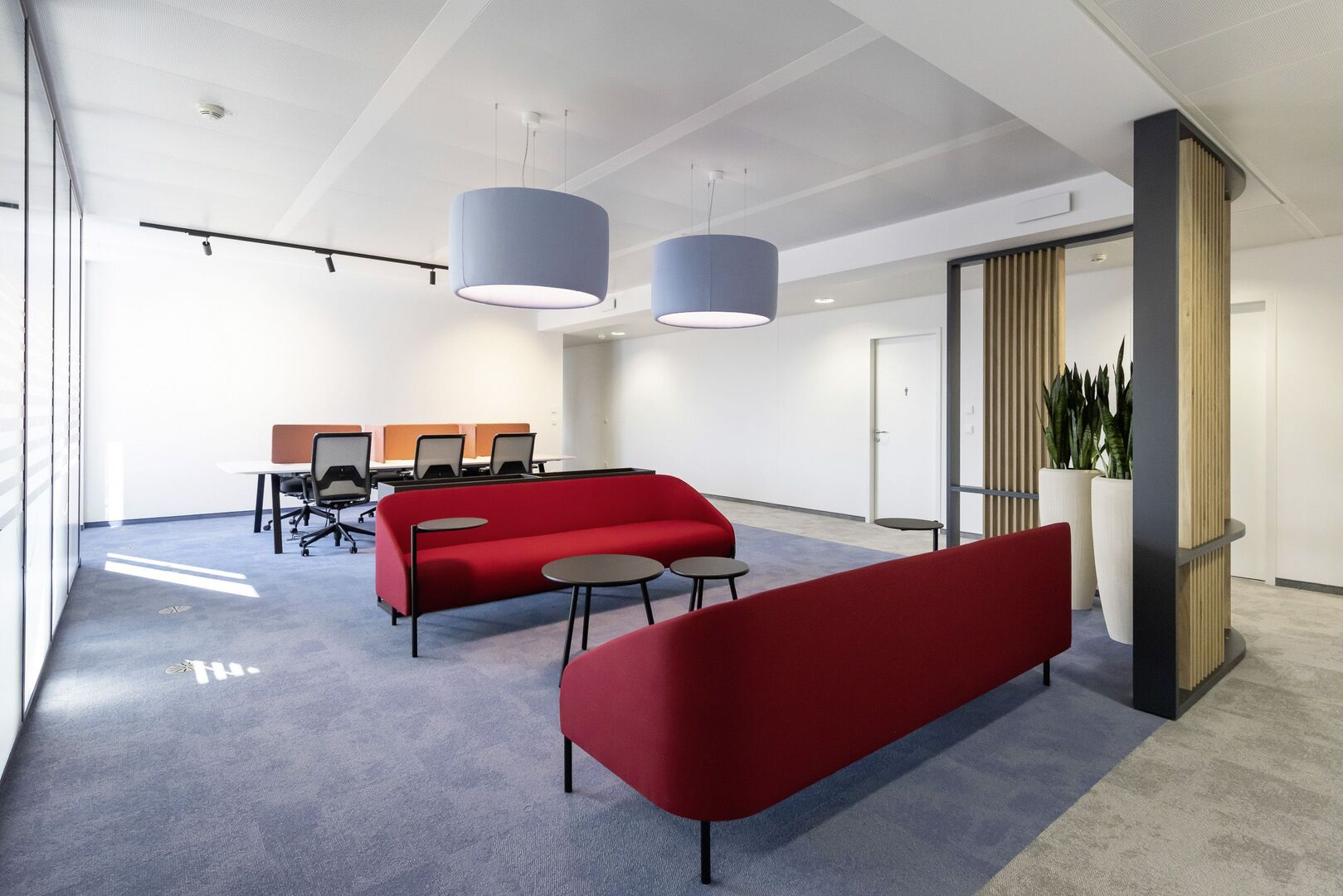 Zwei rote Couches in einem Büroraum | Credit: Daniel Hawelka