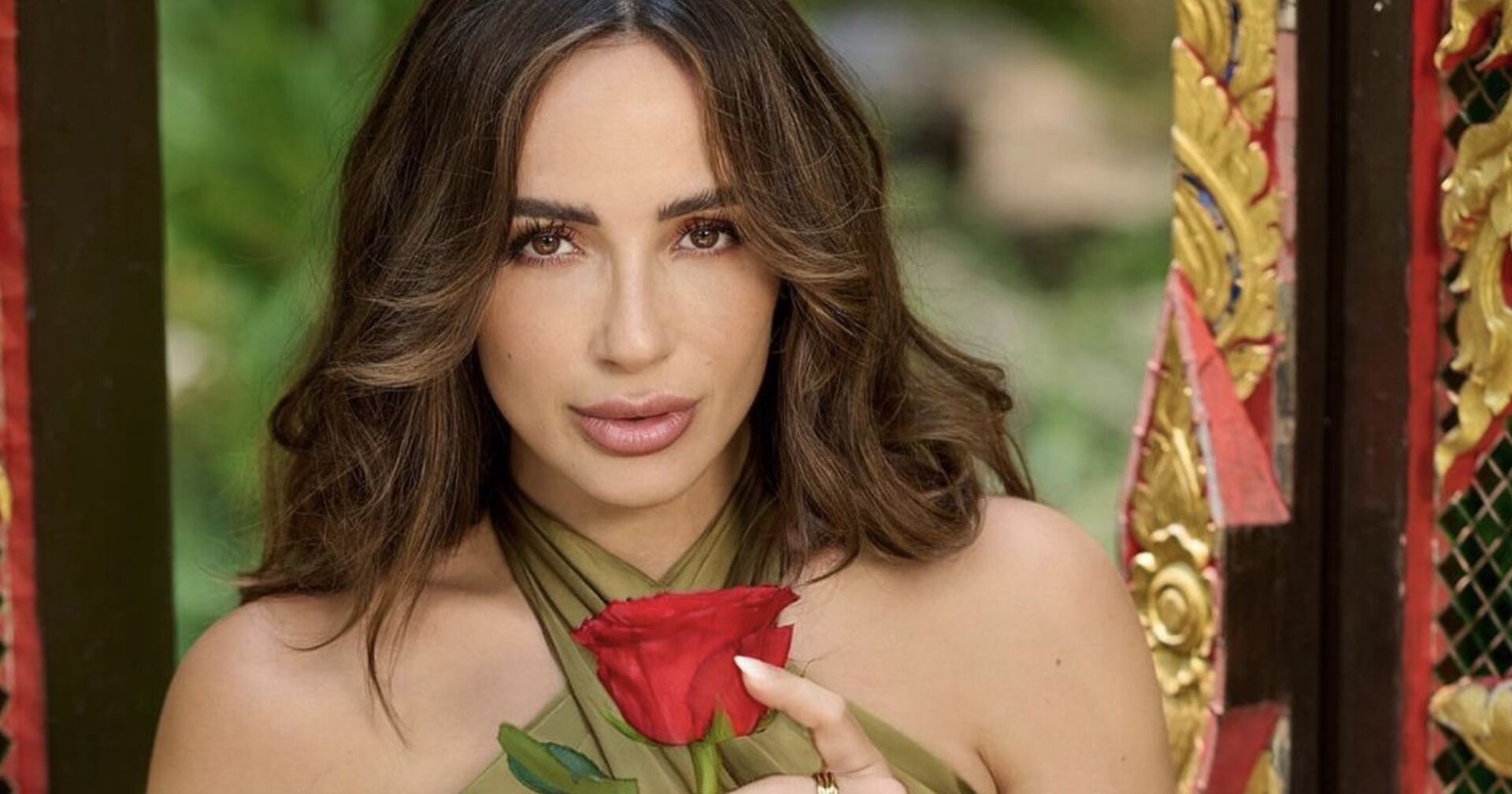 Jennifer Saro mit offenen braunen Haaren und einer Rose in der Hand.