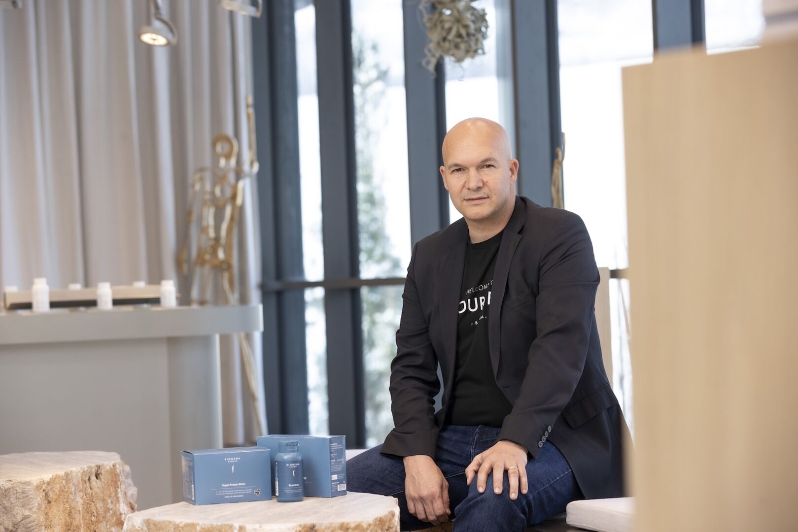 Stefan Klinglmair sitzt auf der Bank, vor ihm die neue Biogena-Sportserie