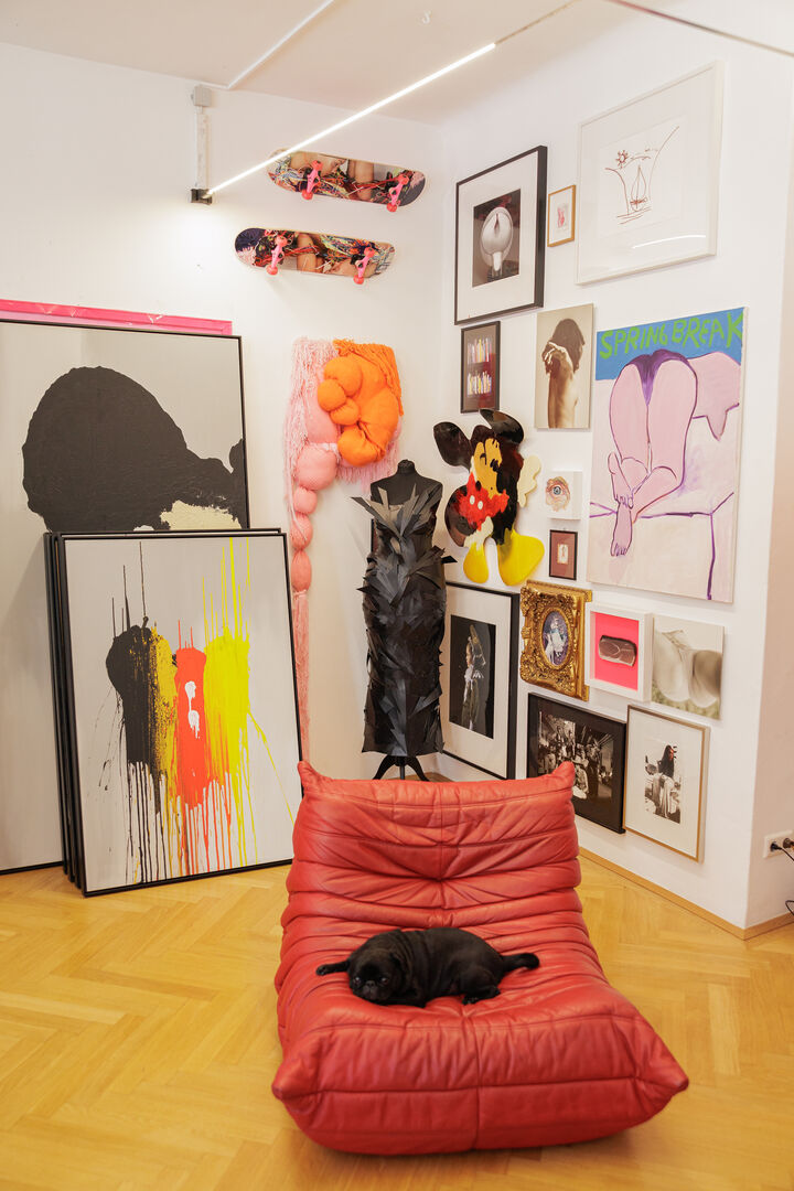 Ein roter Ledersessel steht in Mitten von Bildern