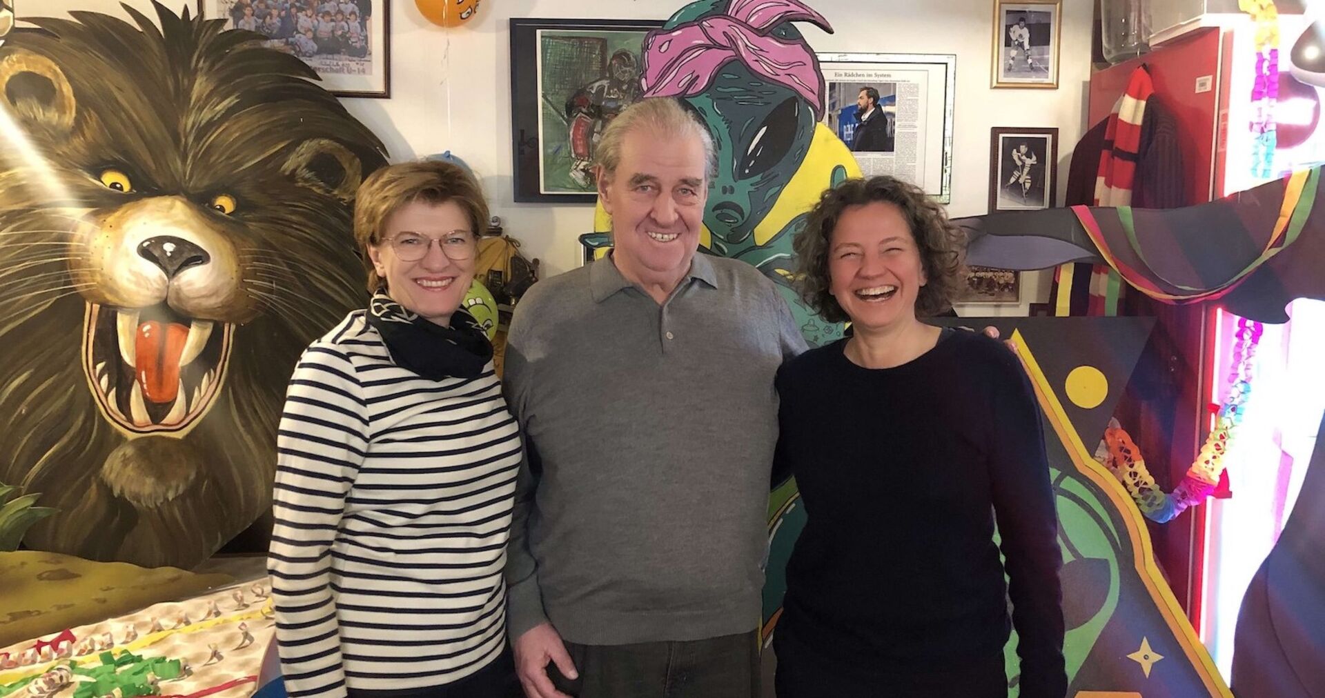 2 Frauen und ein Mann inmitten von Faschingskostümen