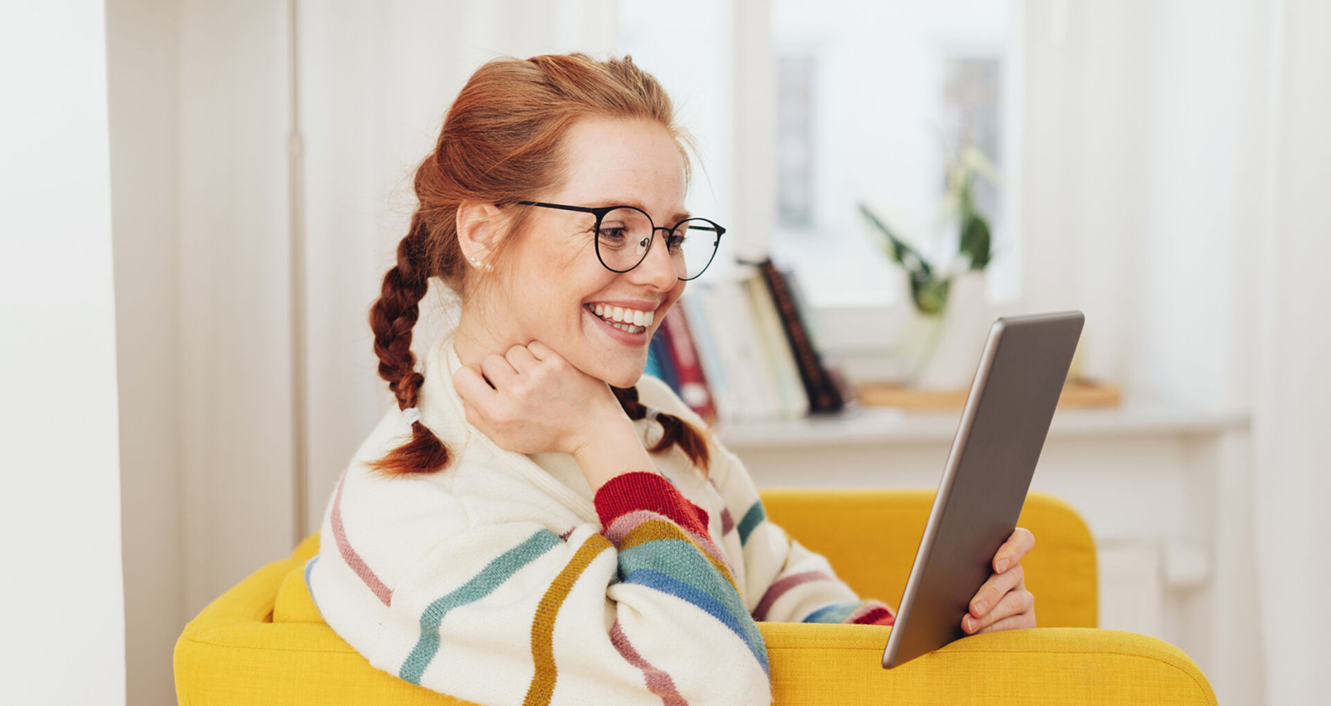 Frau sitzt lächelnd im Sessel | Credit: iStock.com/stockfour