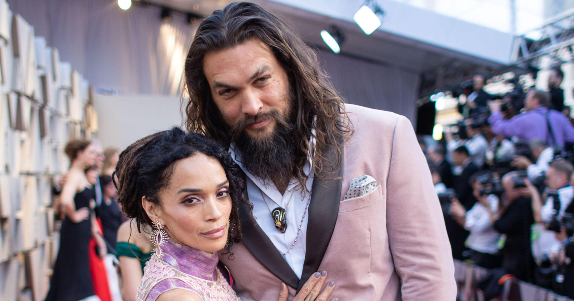 Jason Mamoa und Lisa Bonet in rosa Outfits auf dem roten Teppich.