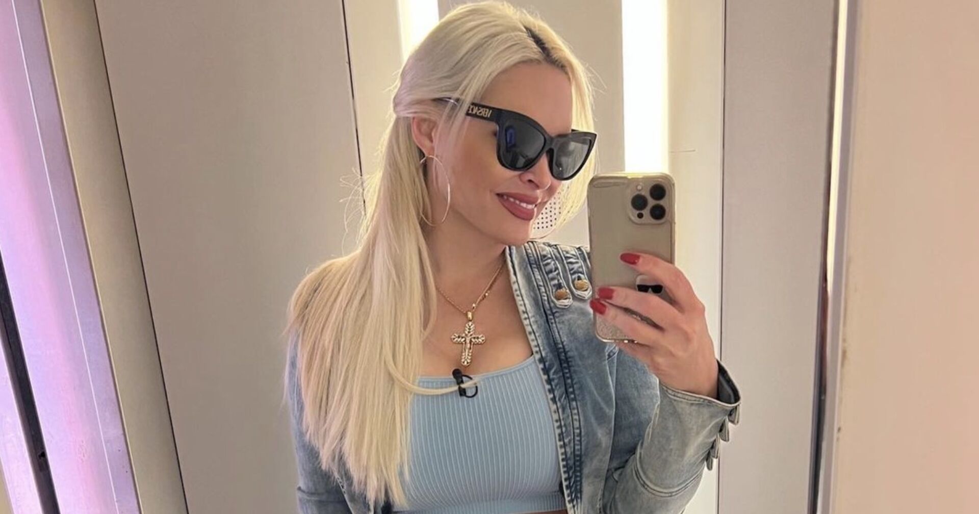 Daniela Katzenberger mit offenen blonden Haaren und einer Sonnenbrille. Sie trägt ein blaues Top.