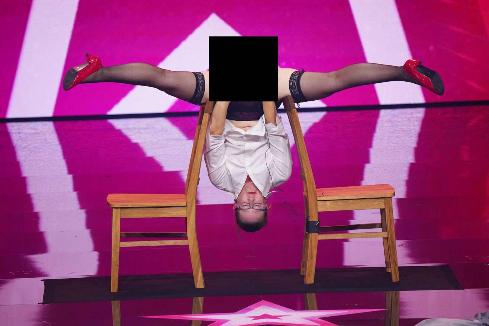Eine Supertalent-Teilnehmerin zwischen zwei Stühlen auf der Bühne.