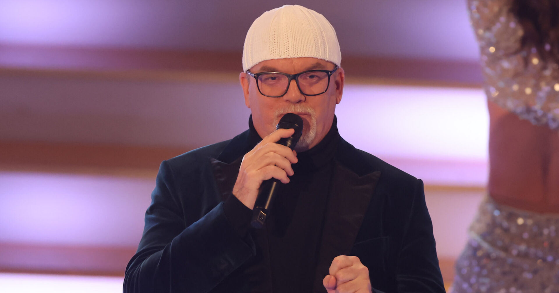 DJ Ötzi auf der Bühne mit einer weißen Mütze und einem schwarzen Sakko.