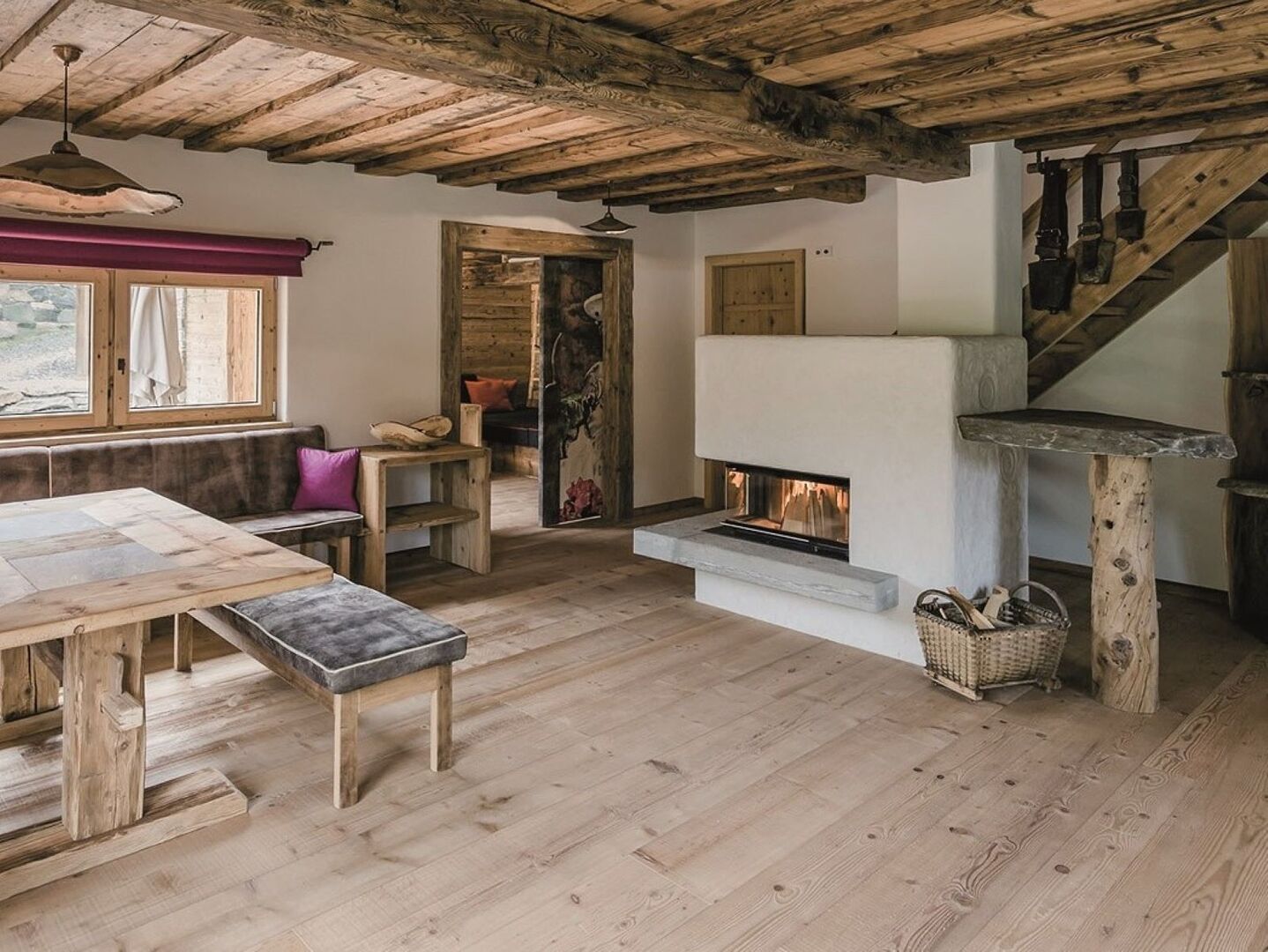 Wohnzimmer mit Kamin, Esstisch und rustikalem Boden