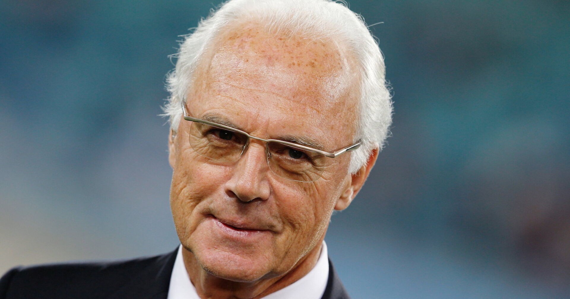 Franz Beckenbauer in einem schwarzen Anzug.