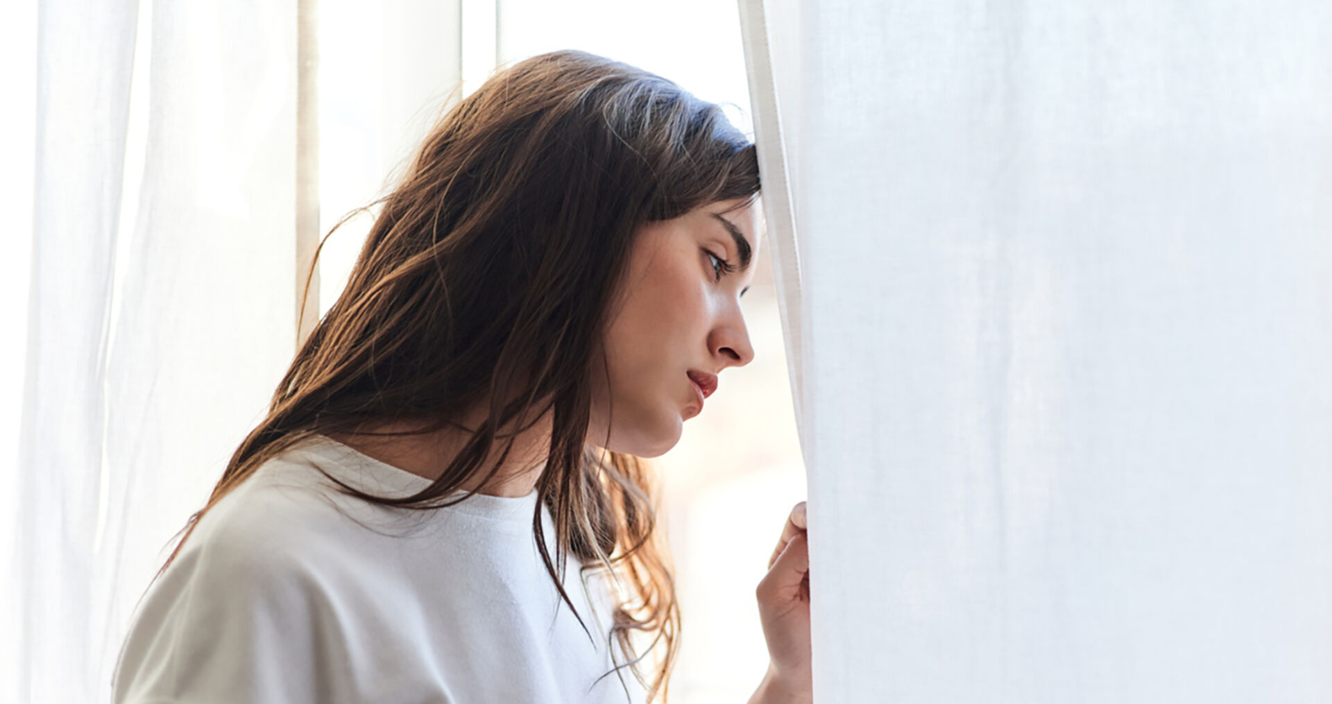 Frau steht am Fenster und grübelt | Credit: iStock.com/Javi Sanz