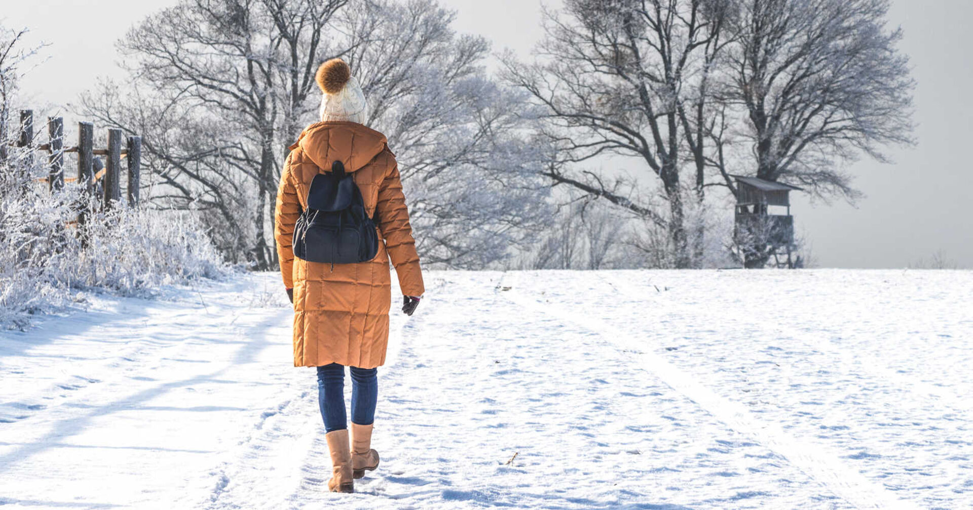 Eine Frau geht im Schnee spazieren.