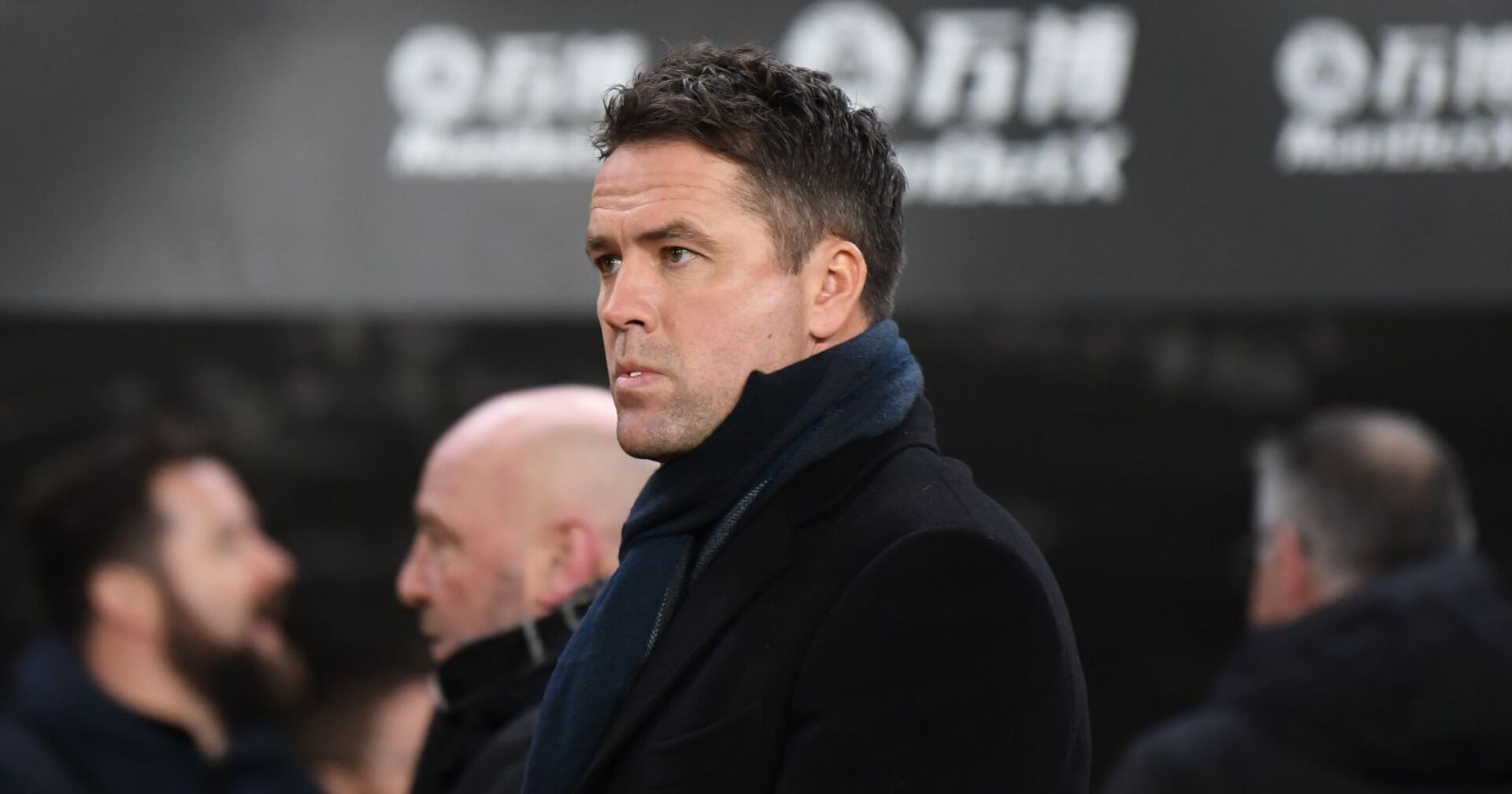 Michael Owen in einem schwarzen Mantel und mit Schal.