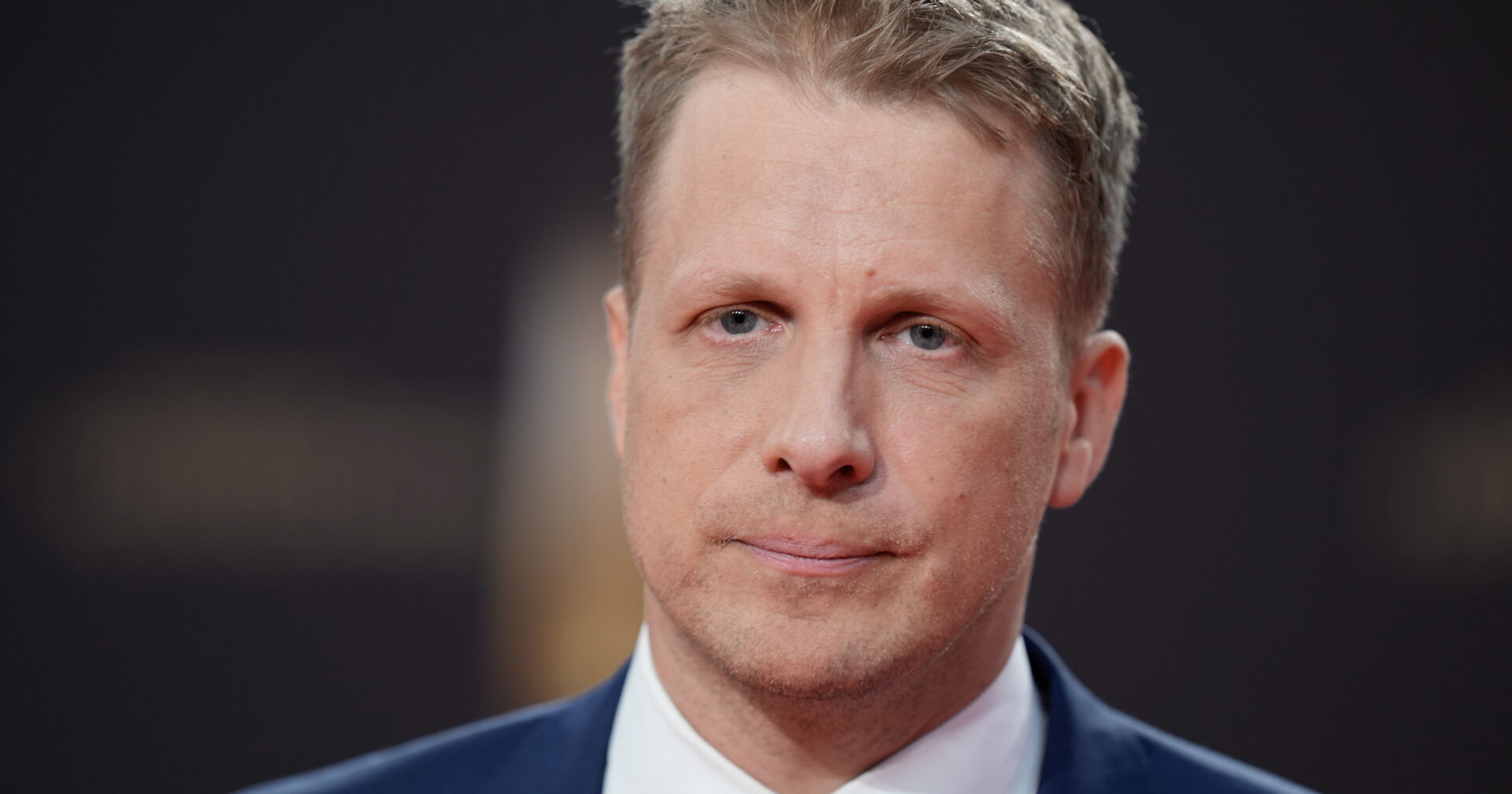 Oliver Pocher mit einem ernsten Gesichtsausdruck und einem Anzug.