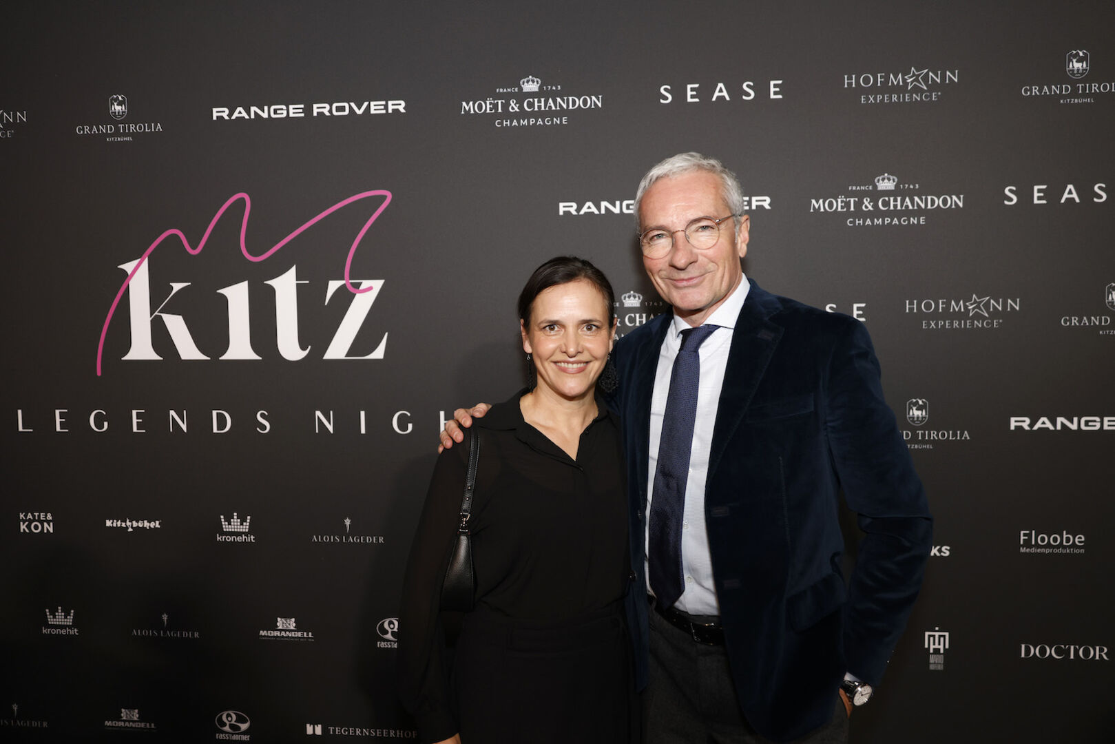 Rainer Pariasek und Eva Pariasek vor einer Fotowand.