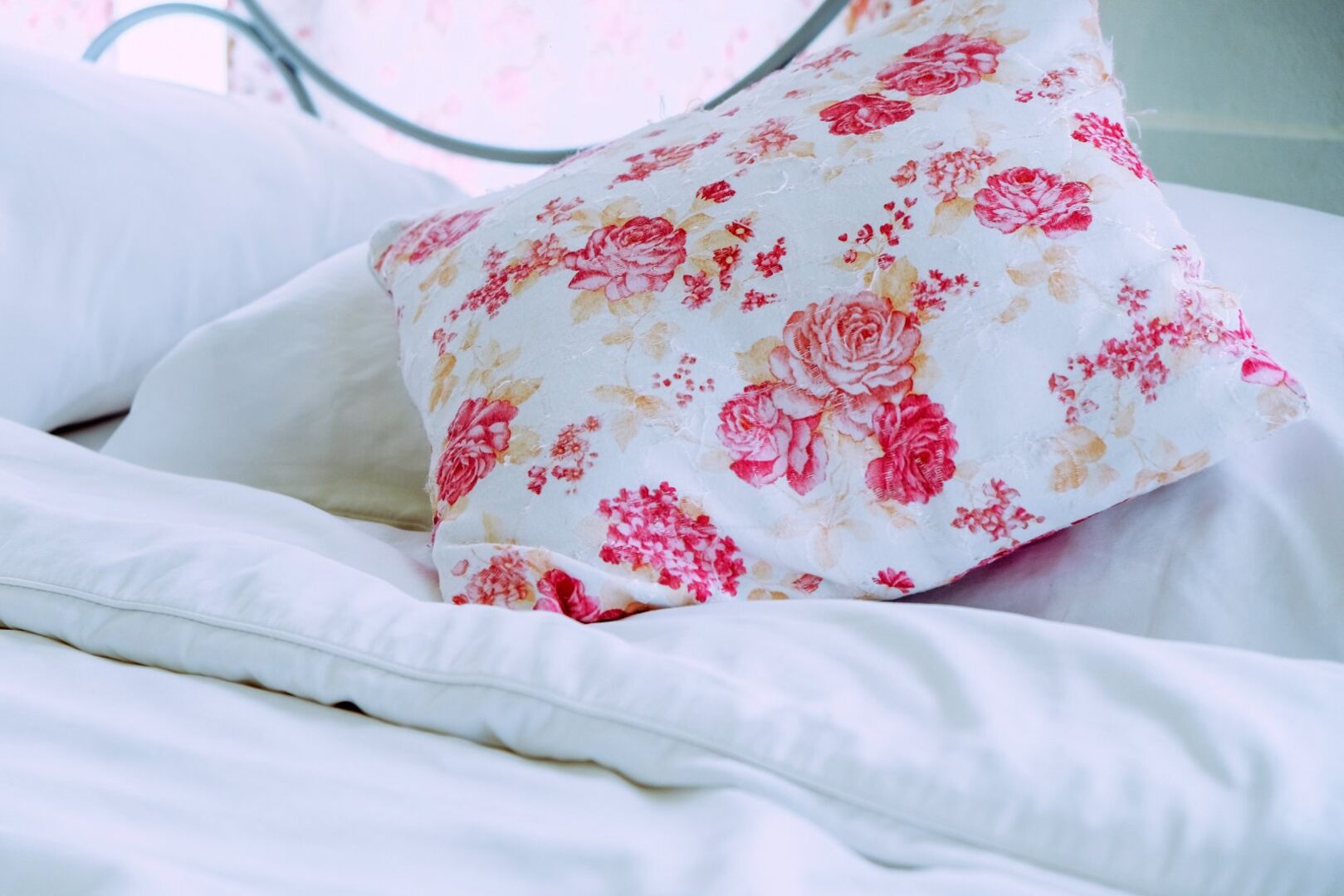 Rosenkissen auf einem Bett | Credit: iStock.com/ponsulak