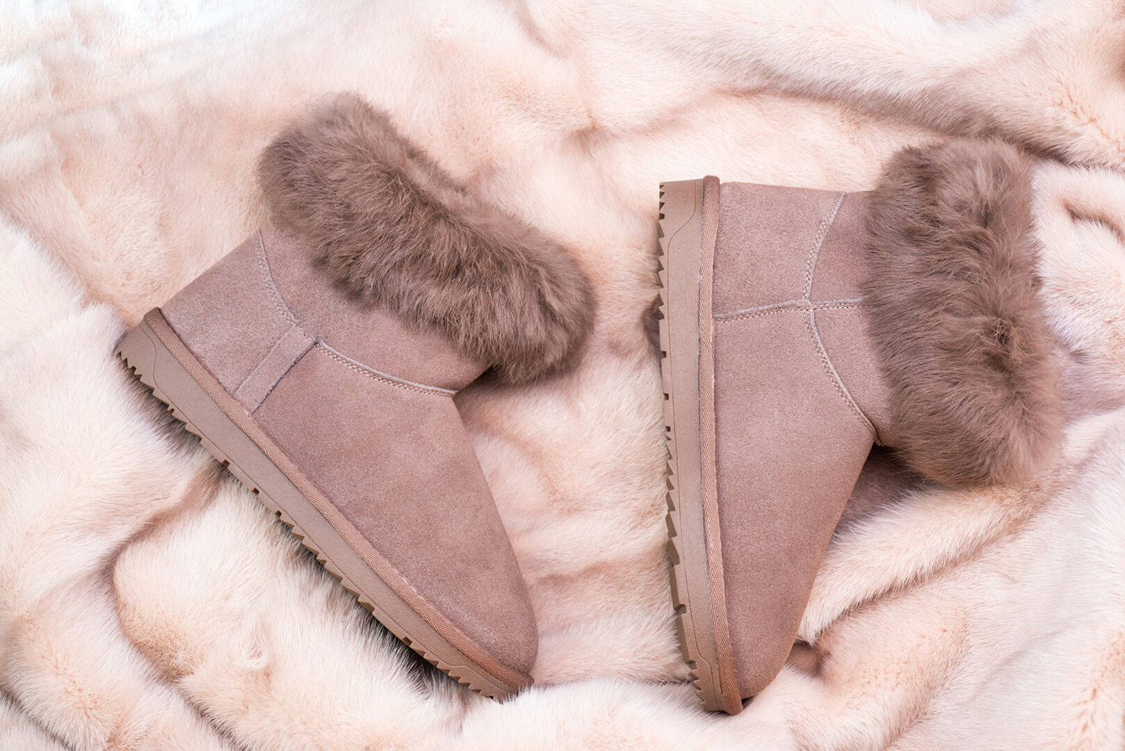 Rosa UGGs auf einer Decke | Credit: iStock.com/photosvit
