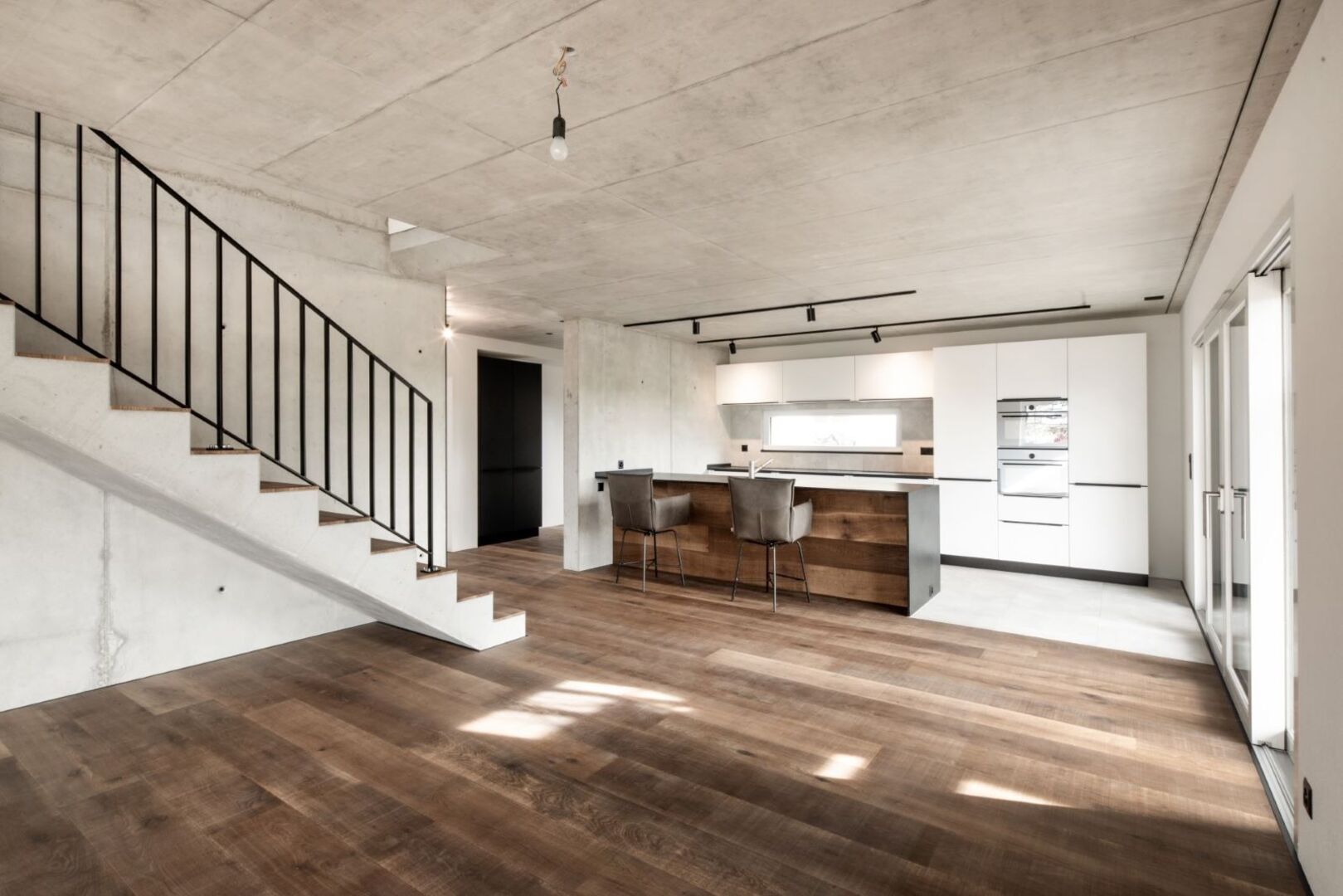 Offenes Wohnzimmer mit Treppenaufgang, Küche und Parekttboden