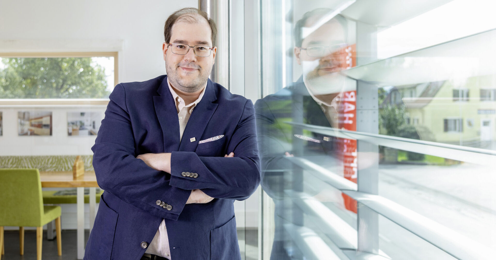 Yves Suter, GF Hartl Haus, lehnt sich an eine Glaswand | Credit: Julia Dejmek