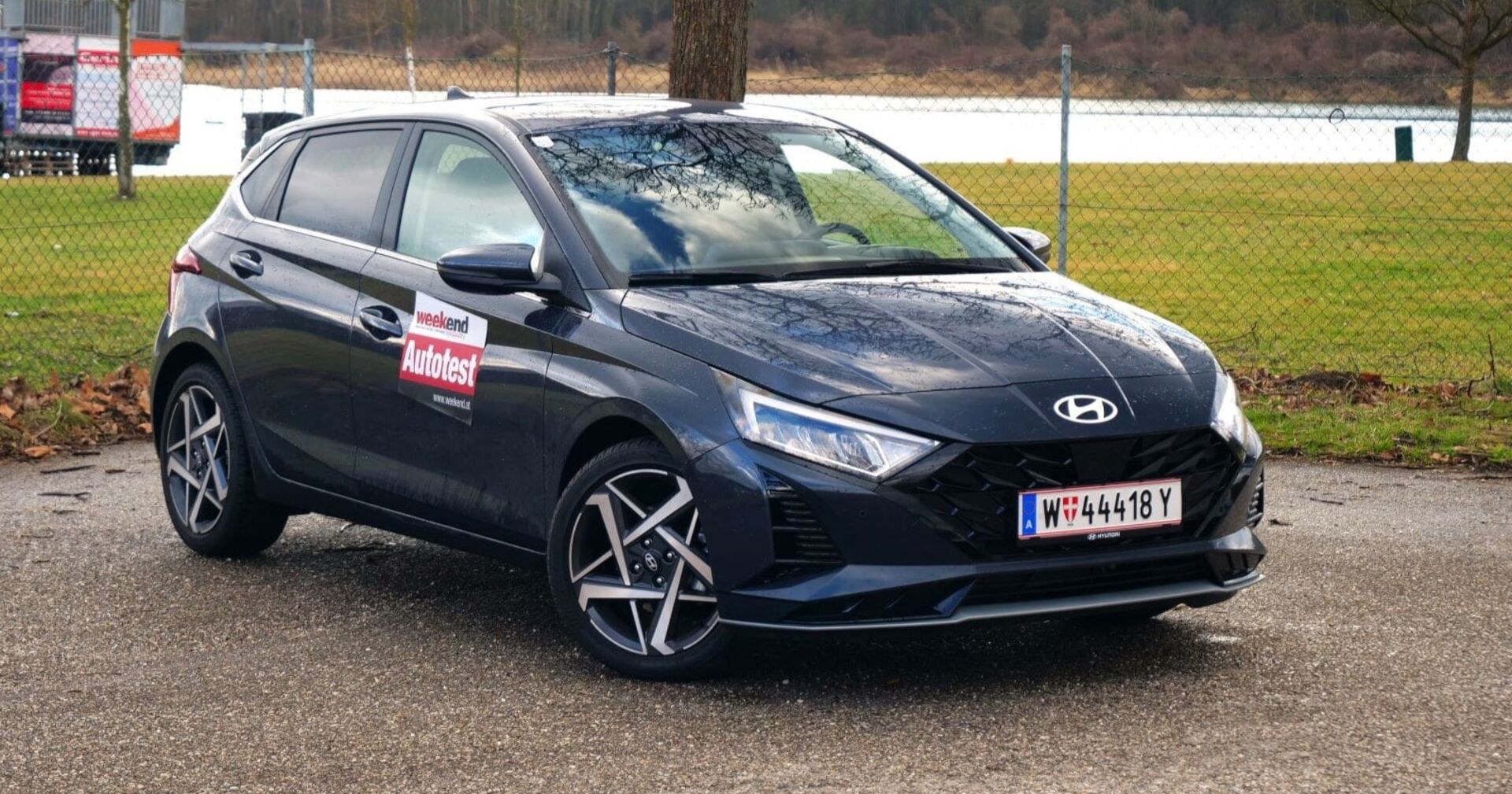 Frontansicht eines schwarzen Hyundai i20, auf der Autotür ein Sticker mit der Aufschrift &quot;Weekend Autotest&quot;