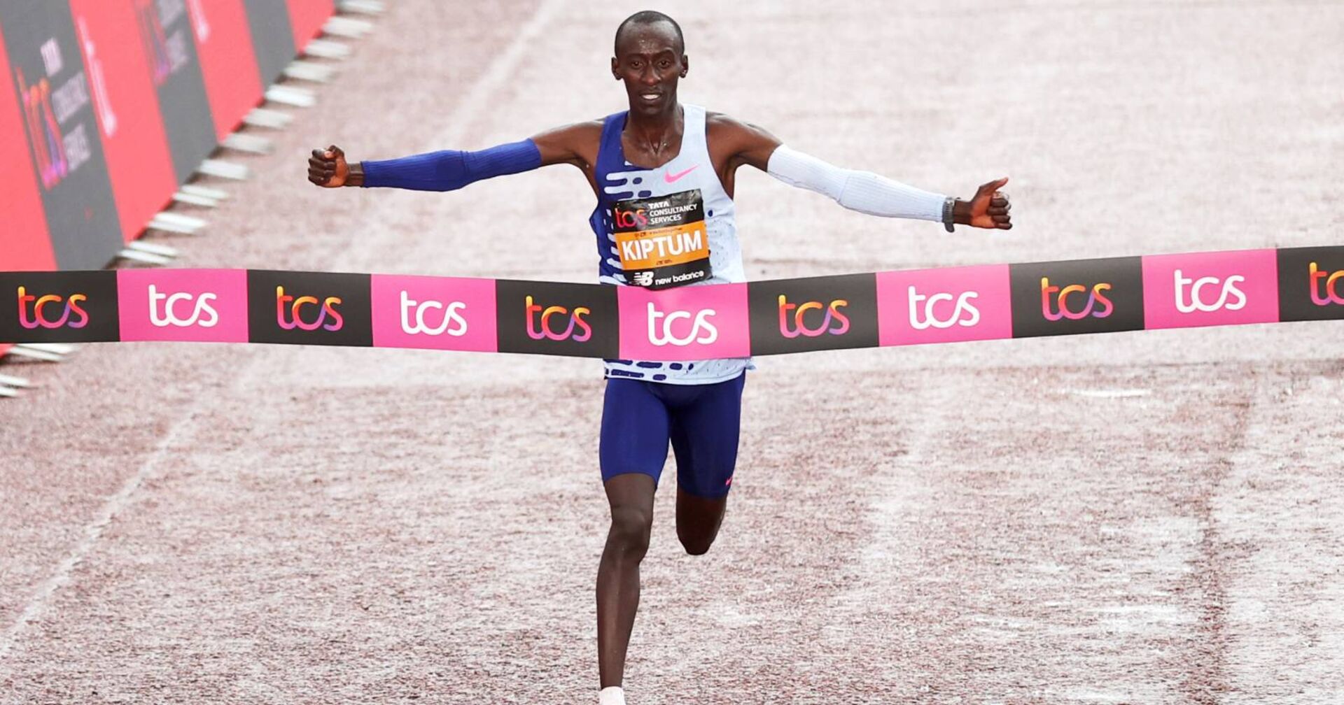 Der kenianische Läufer Kelvin Kiptum, der mit weit ausgebreiteten Armen das Zielband eines Marathons durchläuft