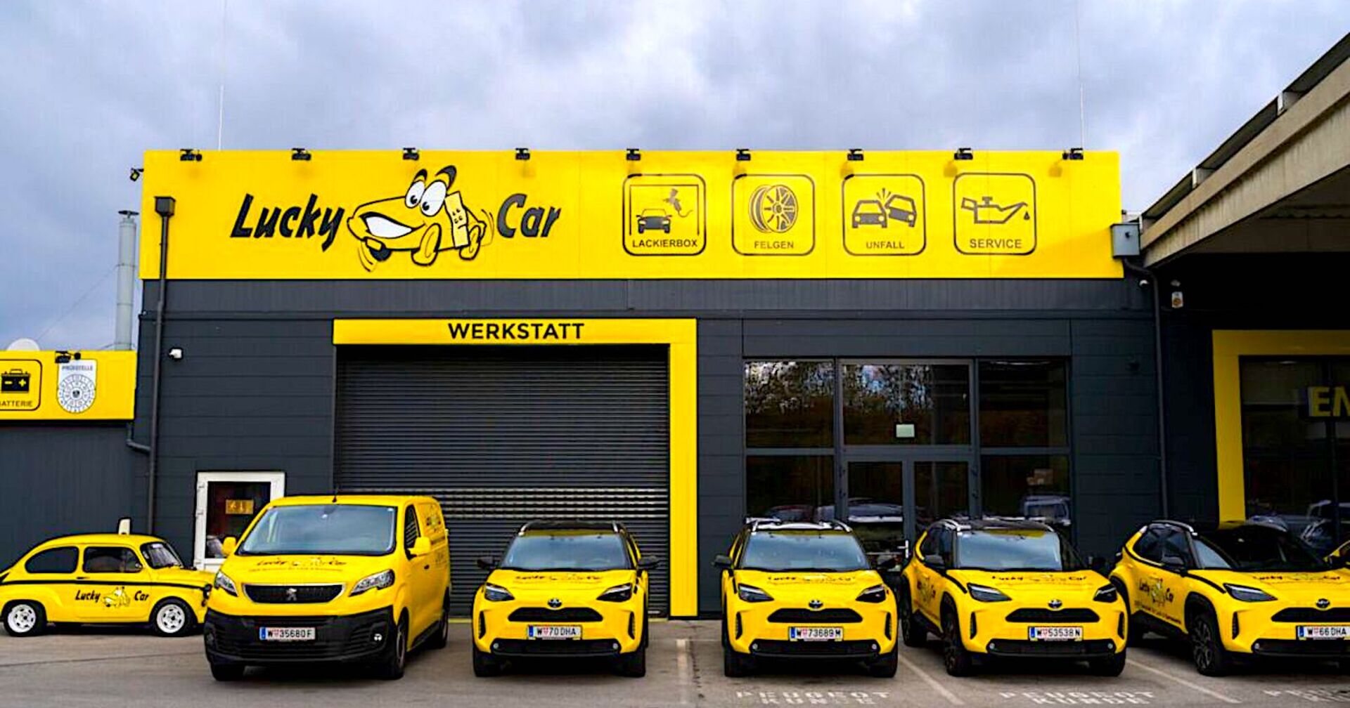 Fahrzeugflotte vor gebrandeter Werkstatt